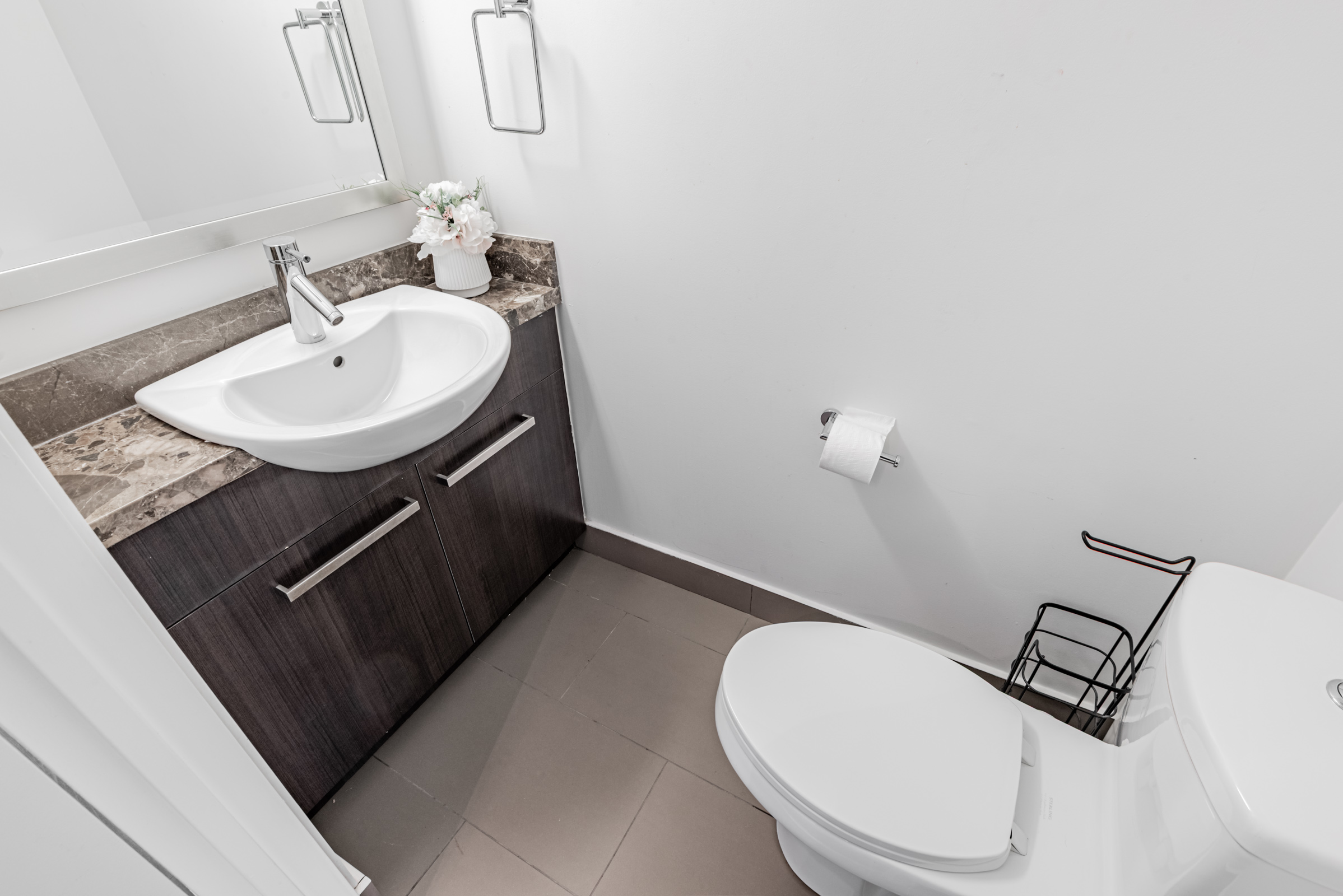 11 St Joseph St Unit 311 powder room with toilet, vanity, mirror and ceramic tiles.
