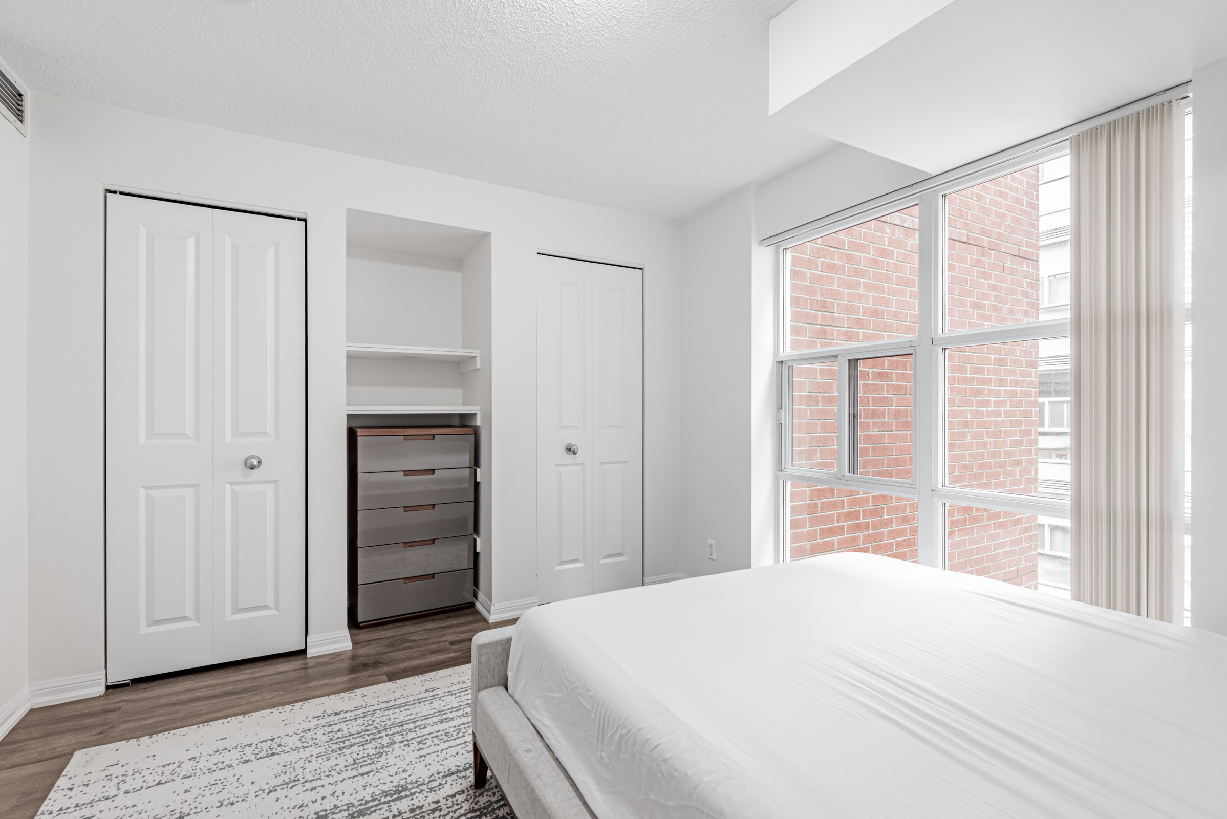 Condo bedroom with his and her closets and storage nook.