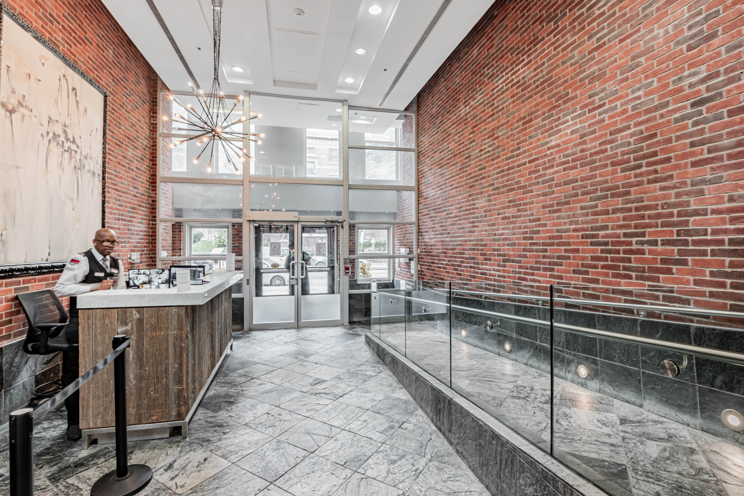Eleven Residences lobby with red-brick walls and modern light fixtures.
