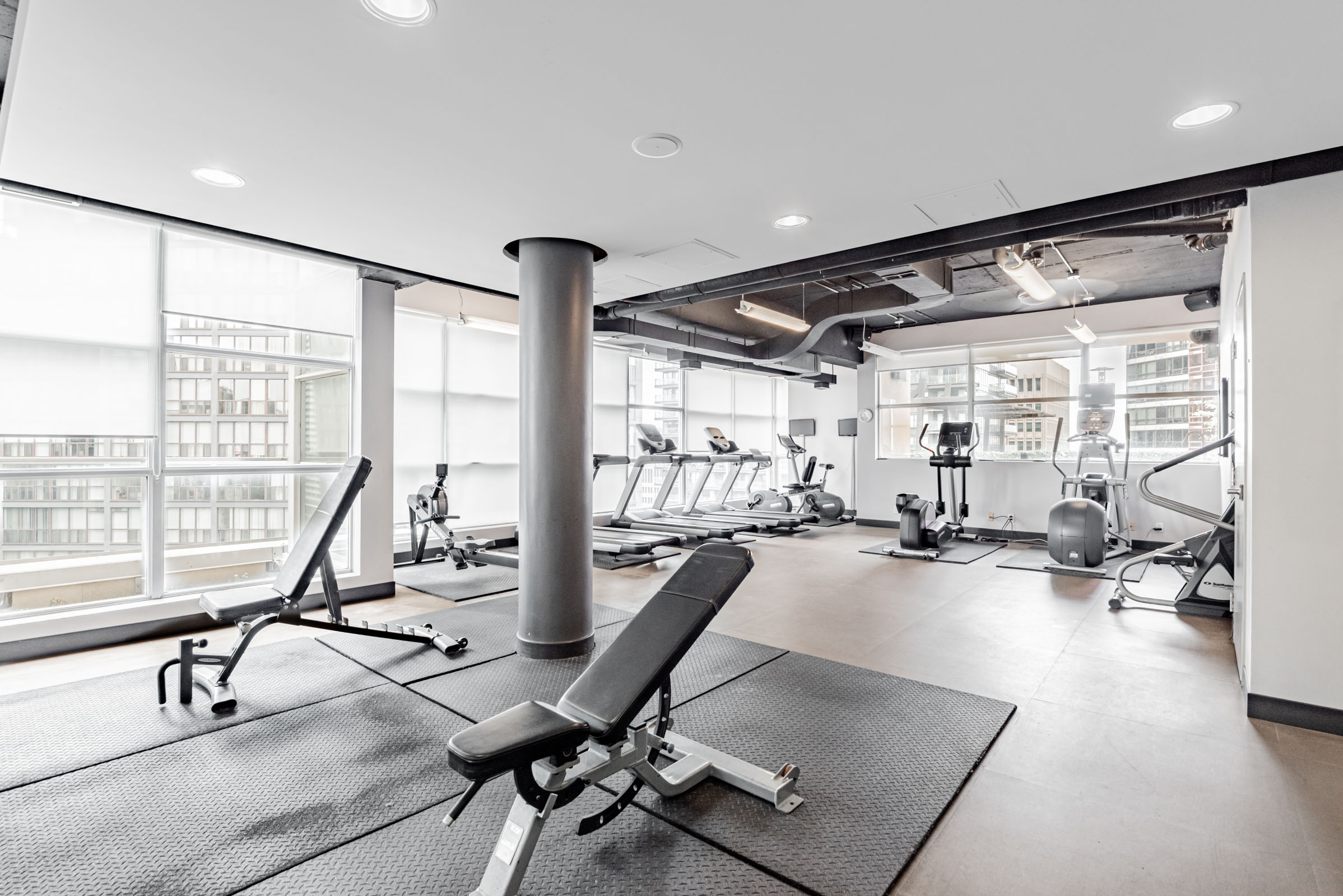 Eleven Residences gym amenity with large windows and exercise equipment.