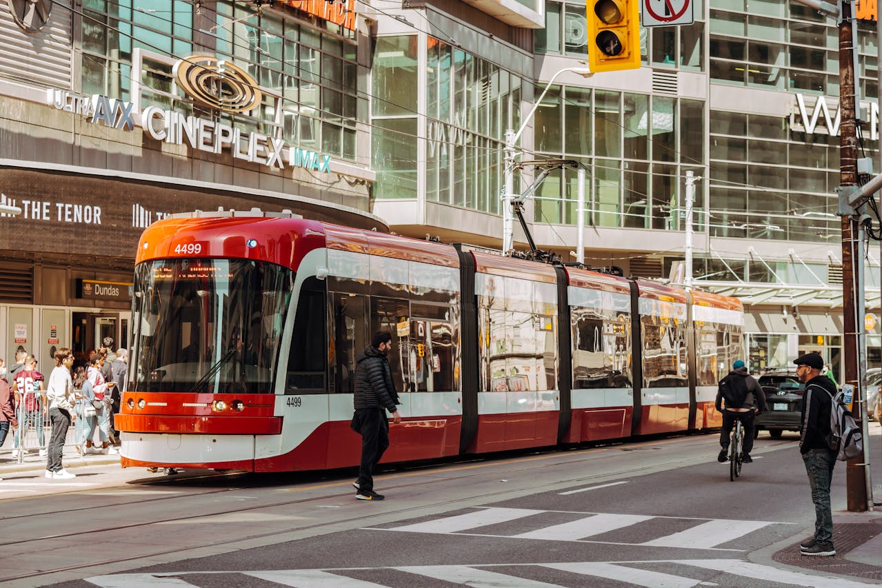 Red TTC streetcar and pedestrians in downtown Toronto.