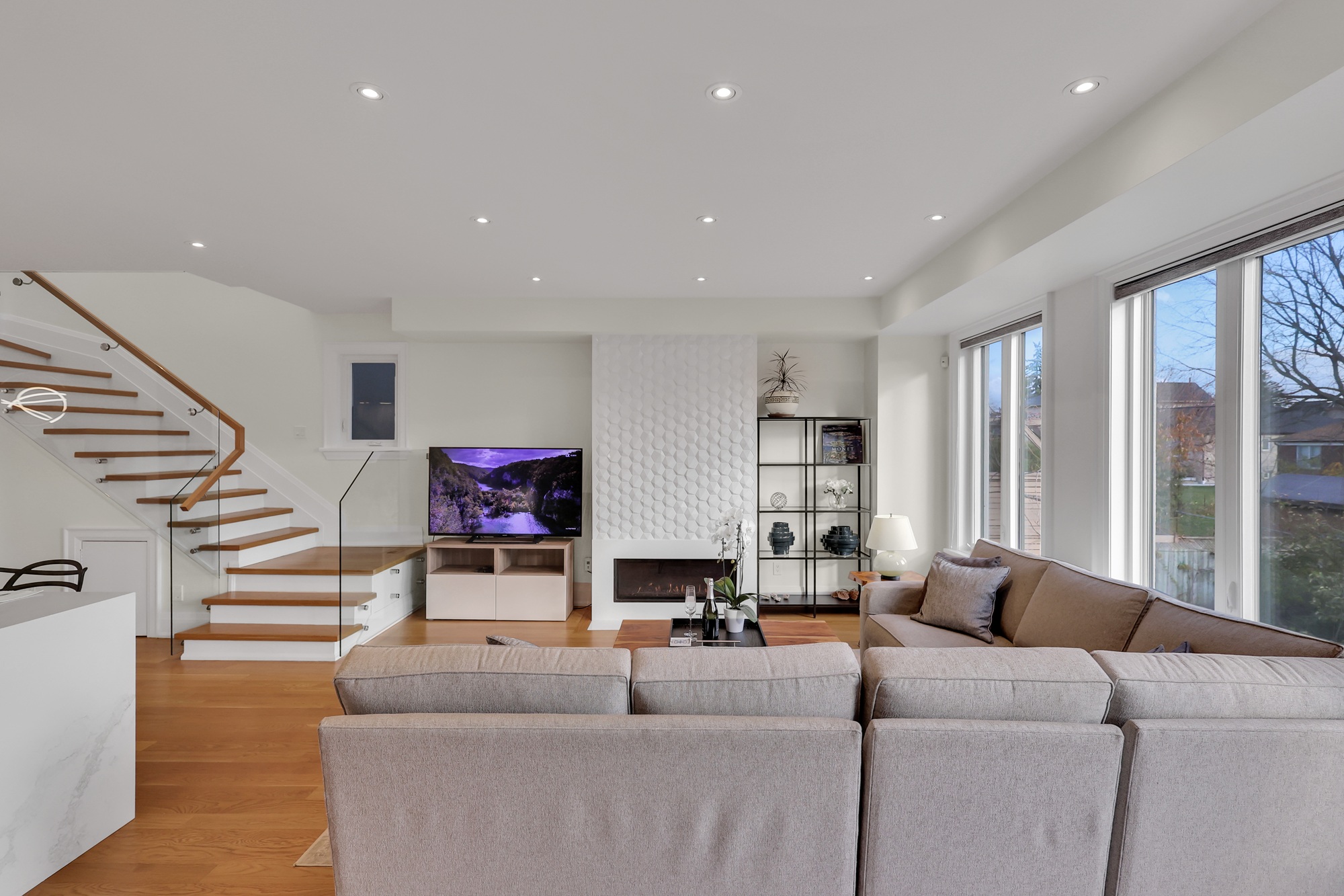 Minimalist fireplace set into feature wall with geometric tiles. 