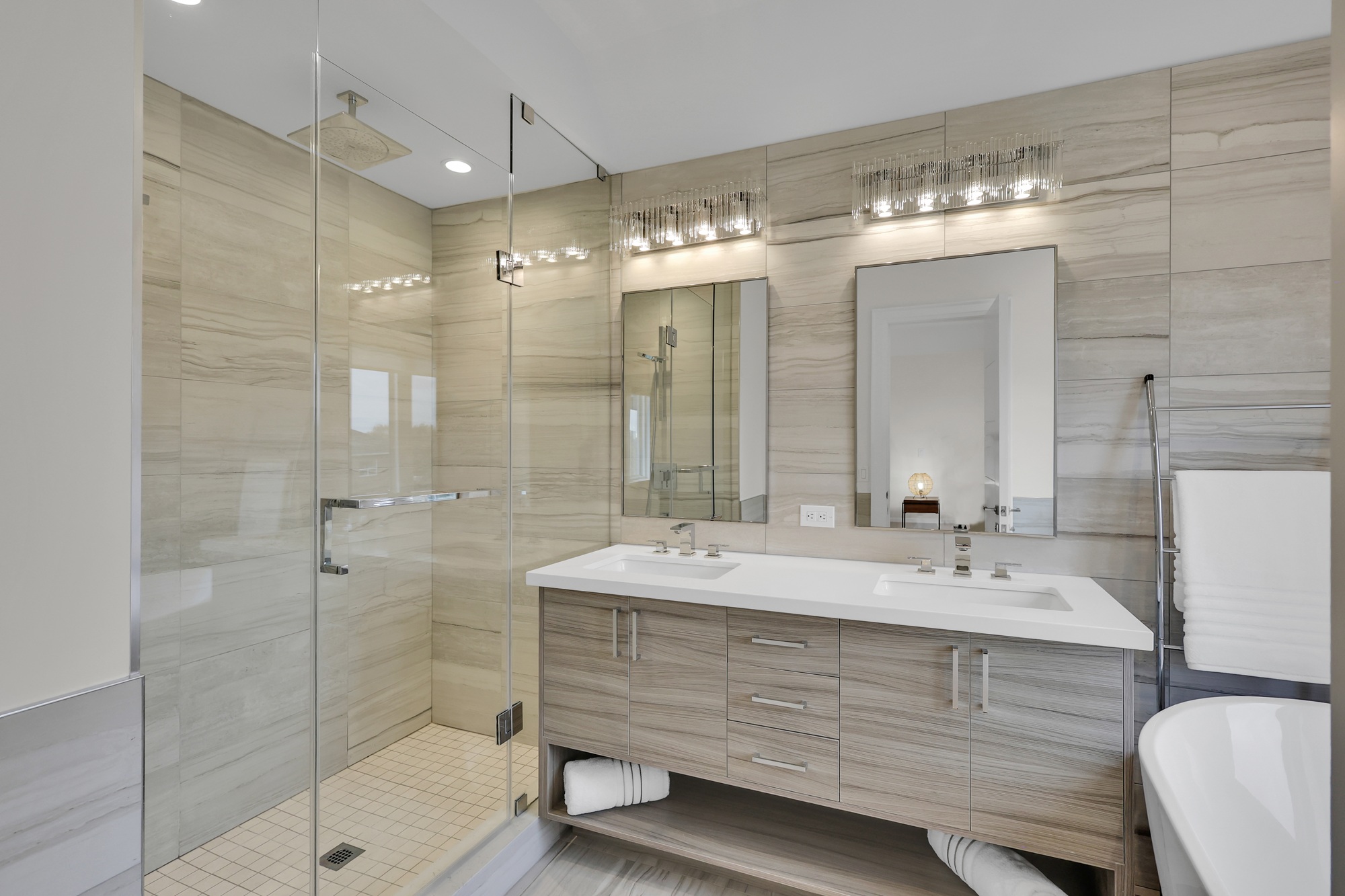 743 Glencairn Ave 5-piece ensuite bath with dual sinks, storage, multi-light sconces, ceramic tiles, and frameless glass shower with a rain shower head.