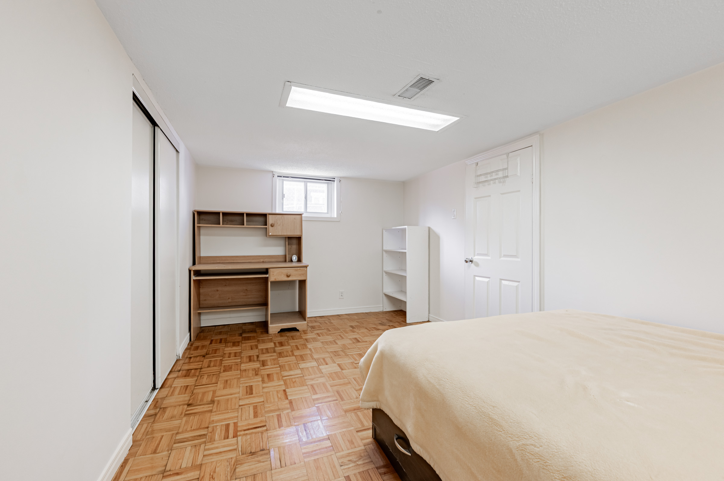 Basement with empty work desk and shelves.