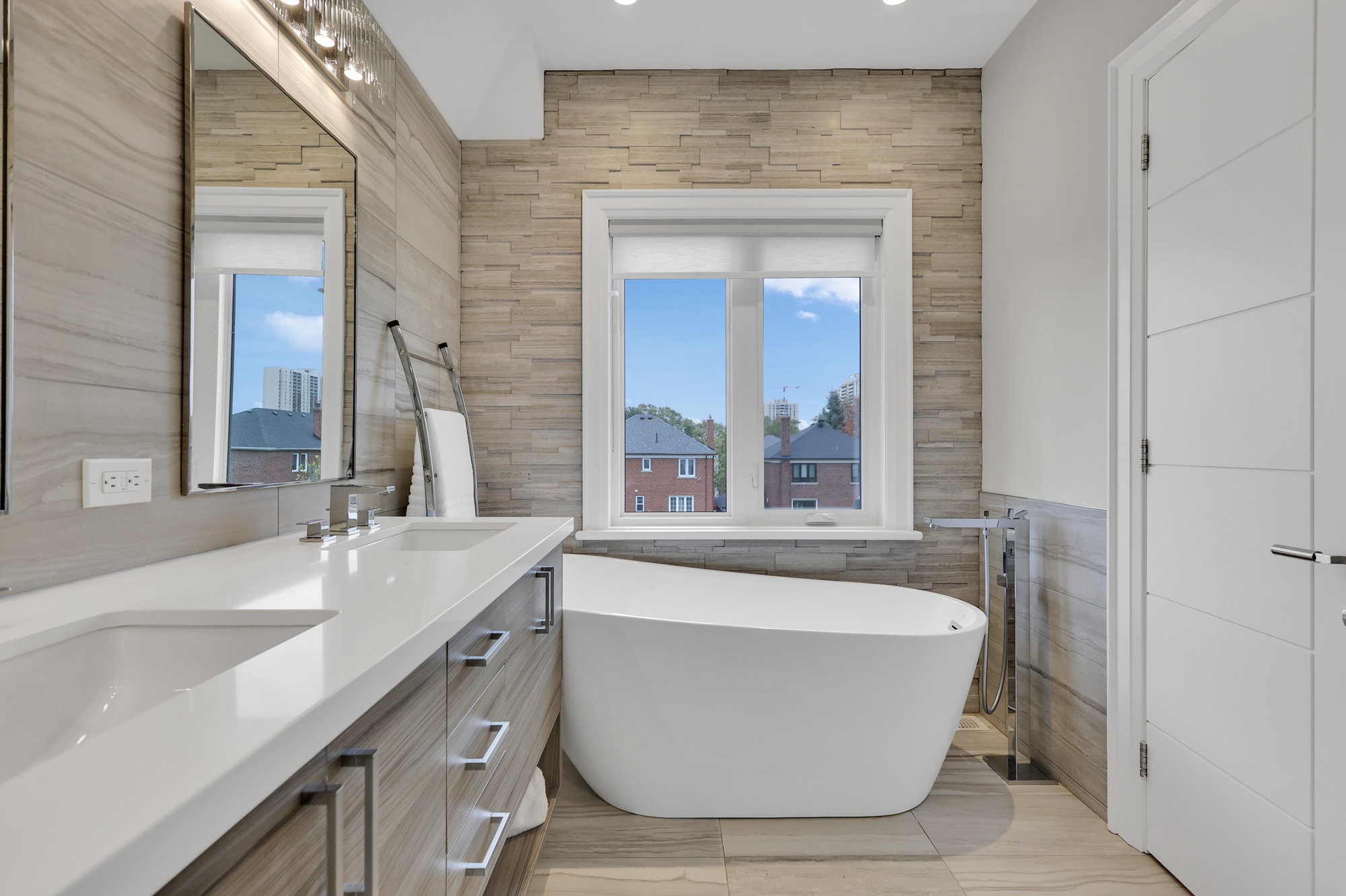Curved freestanding white soaker tub with floor-mounted tub filler. 
