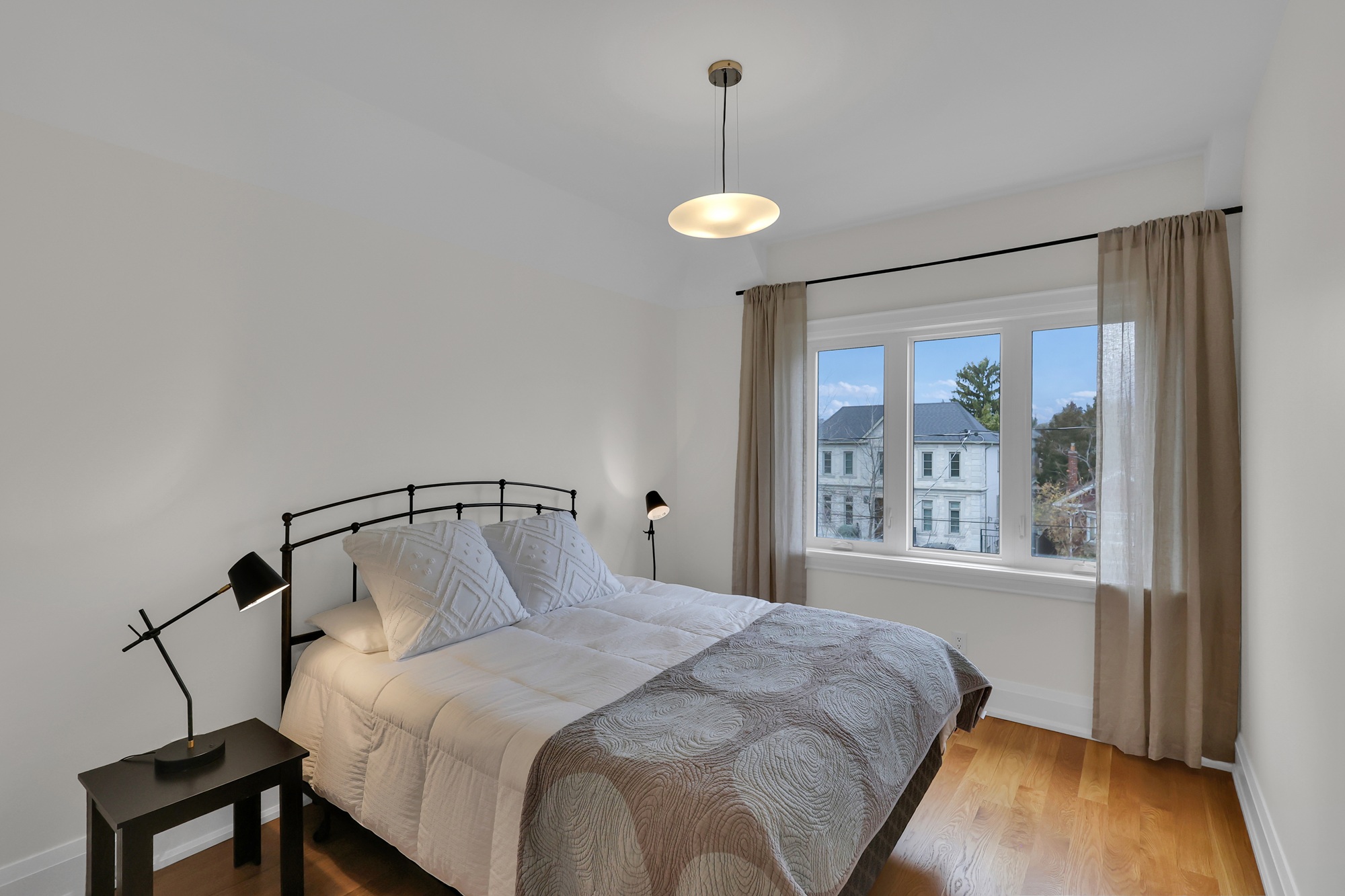 743 Glencairn Ave third bedroom with bed, night stands, hardwood floors and window showing view of street.