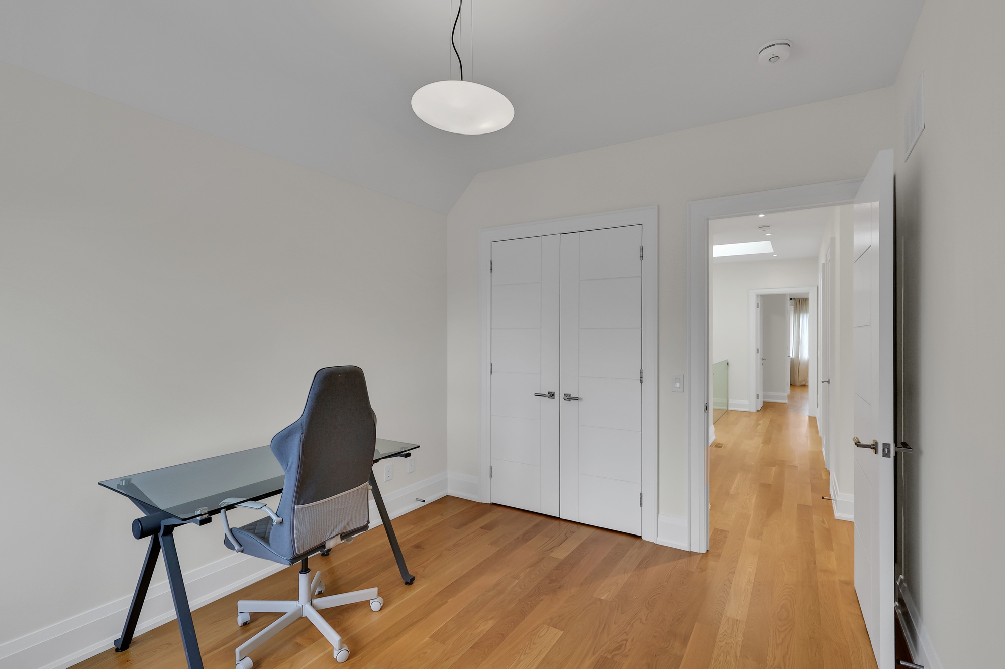 Bedroom with desk, chair and double-door closet.