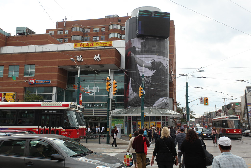 Exterior of Dragon City Mall in Toronto with view of cars, pedestrians and streetcars.