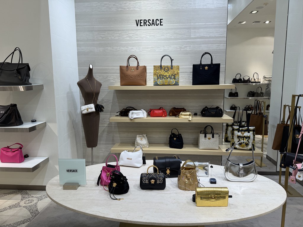 Versace store display with handbags and mannequins.