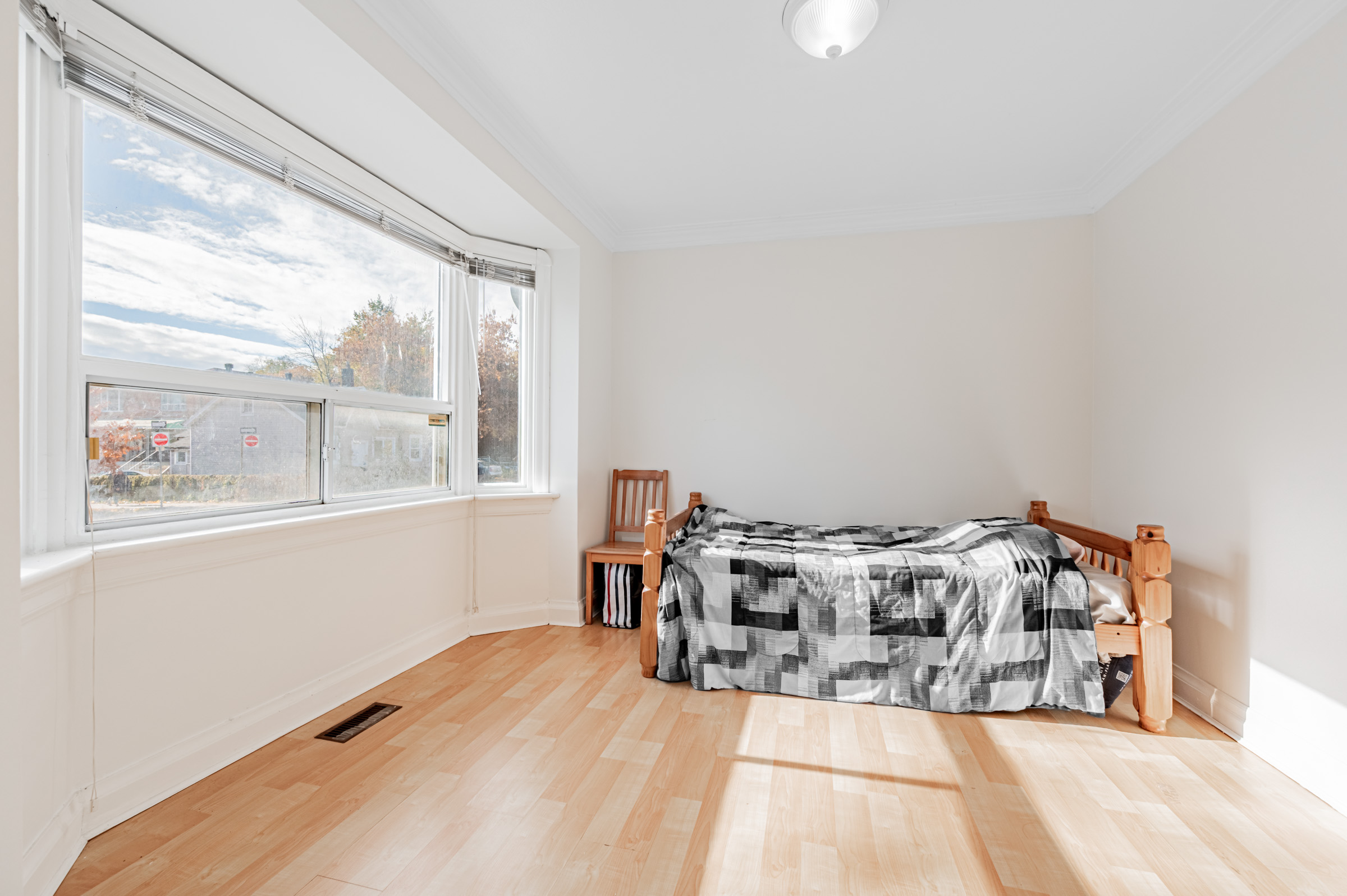 42 Carr St living room with bed, bay windows and hardwood floors.