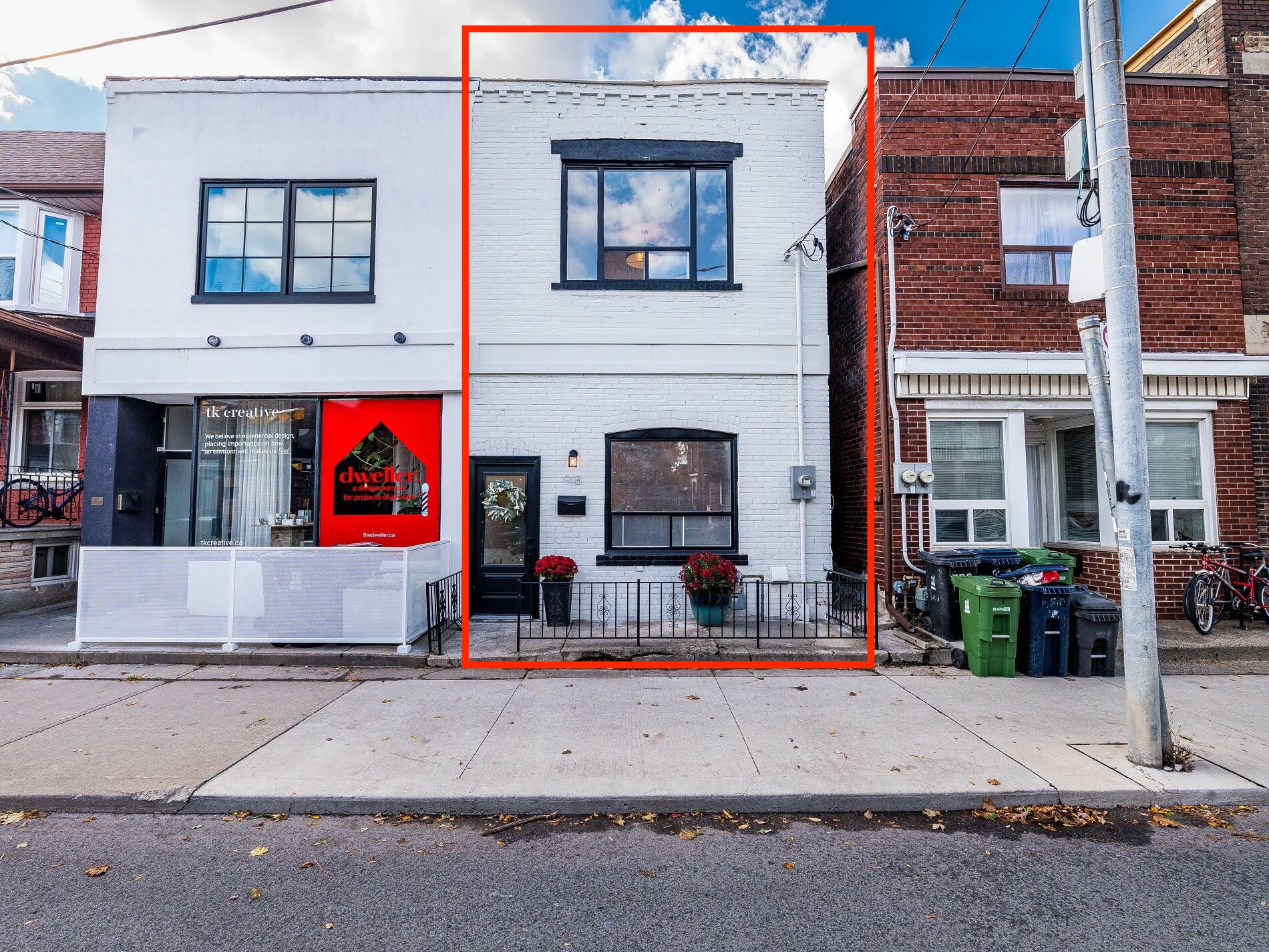 918 Ossington Ave exterior showing white-brick facade, black trim windows, sidewalk, and surrounding buildings.