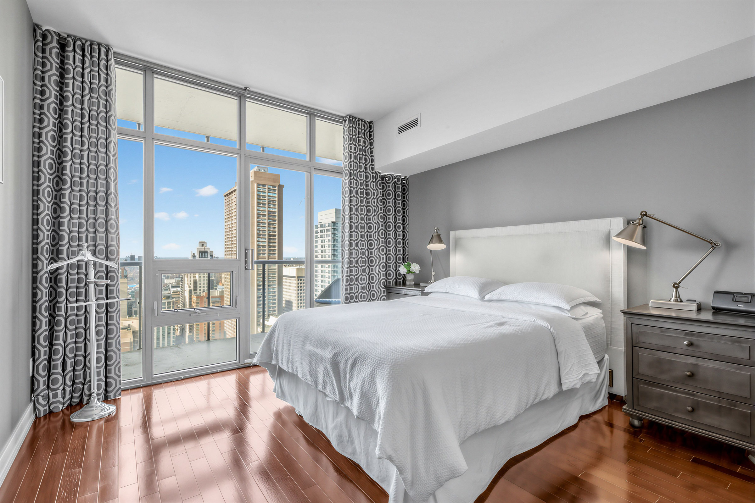 Large primary bedroom with floor-to-ceiling windows and large bed – 33 Charles St E Unit 3206.