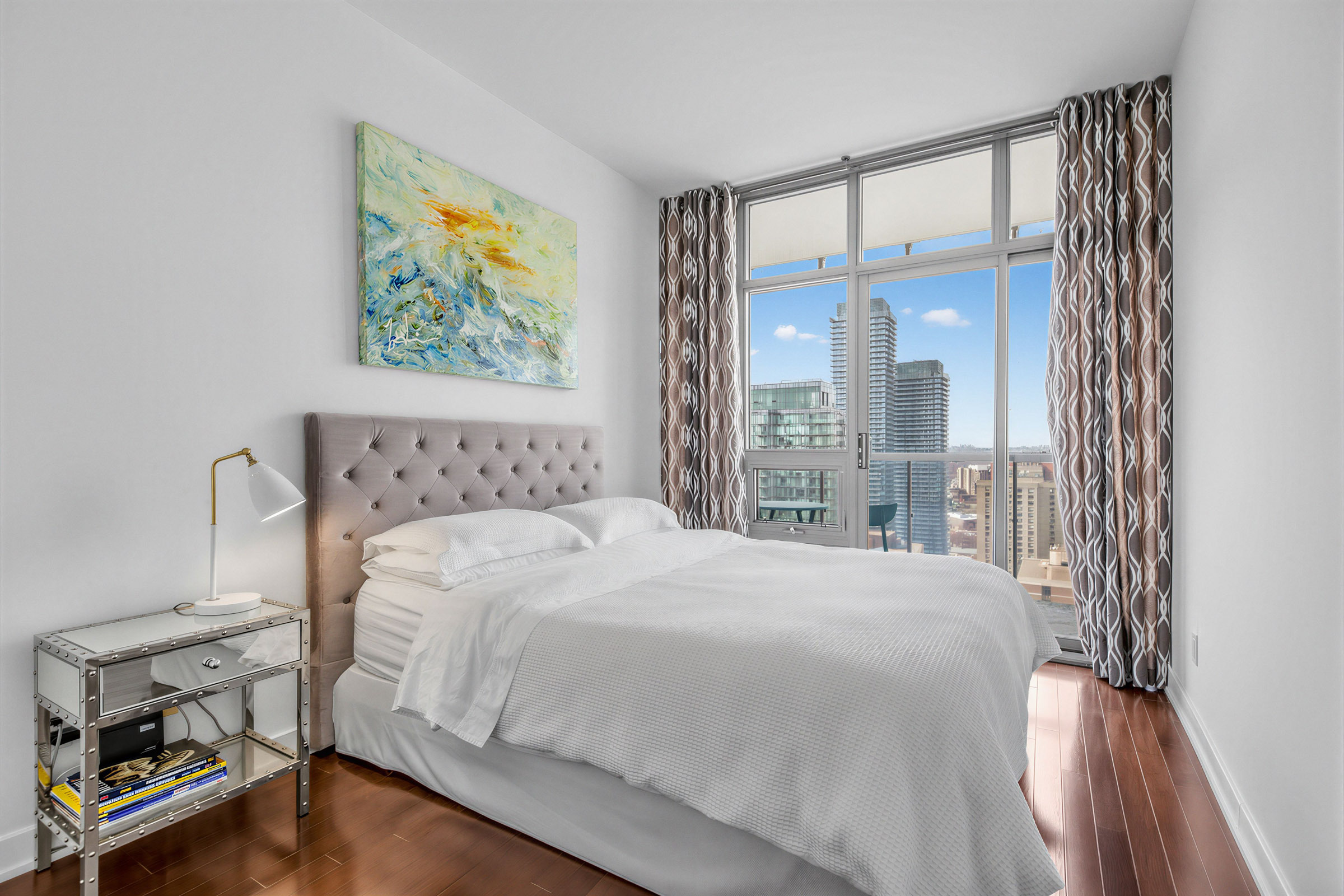 33 Charles St E Unit 3206 second bedroom with floor-to-ceiling windows and view of skyline.