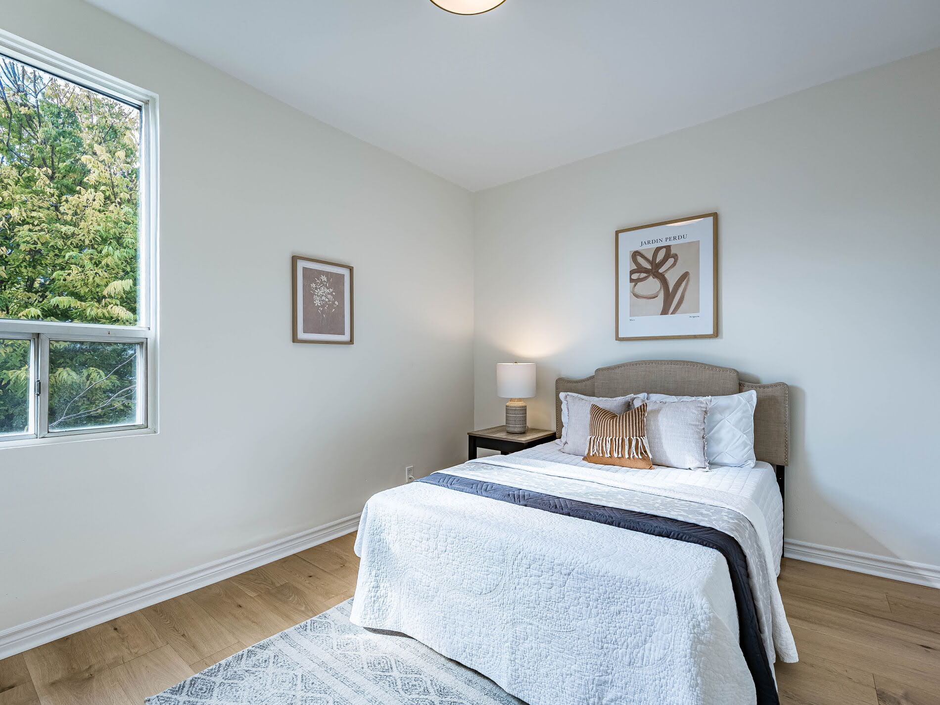 918 Ossington Ave third bedroom with bed and window showing view of trees.