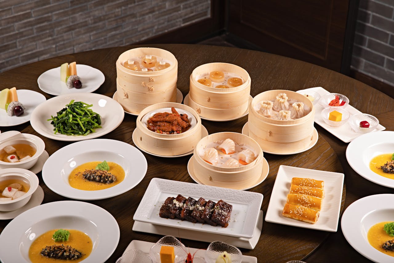 Round table set with plates, bowls and containers of Chinese food.