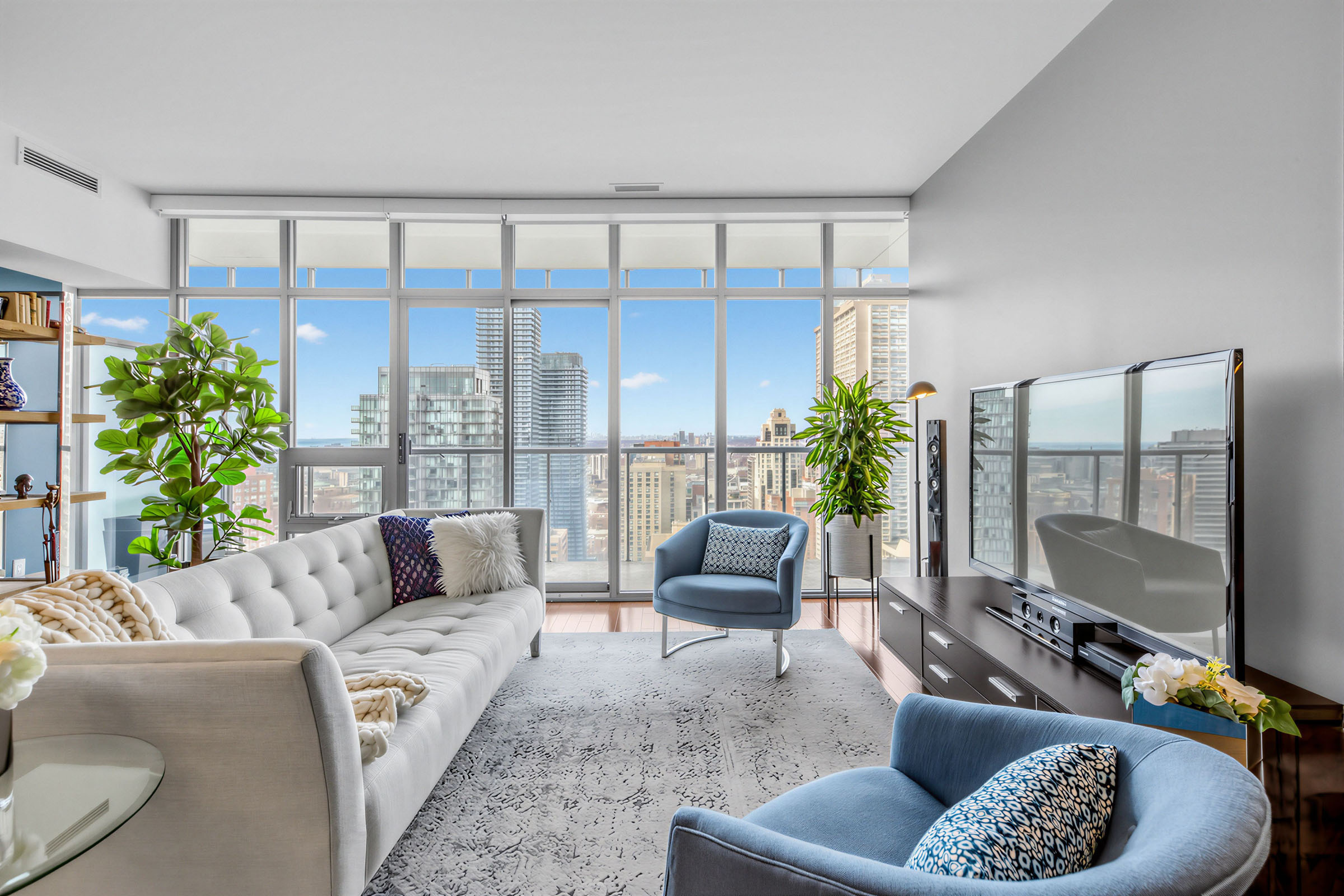 Living room with floor-to-ceiling windows and view of Toronto skyline.