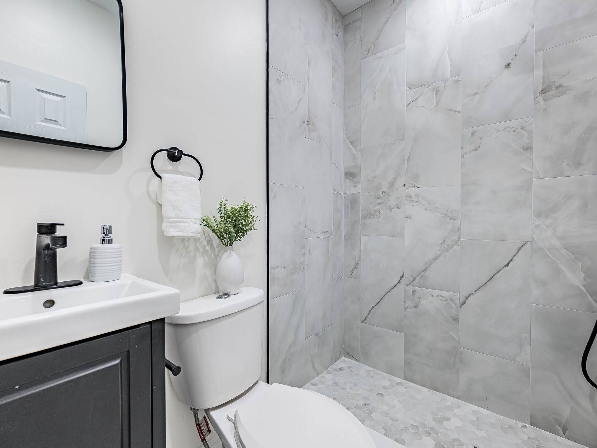918 Ossington Ave new 3-piece basement bathroom with white tiles in walk-in shower.