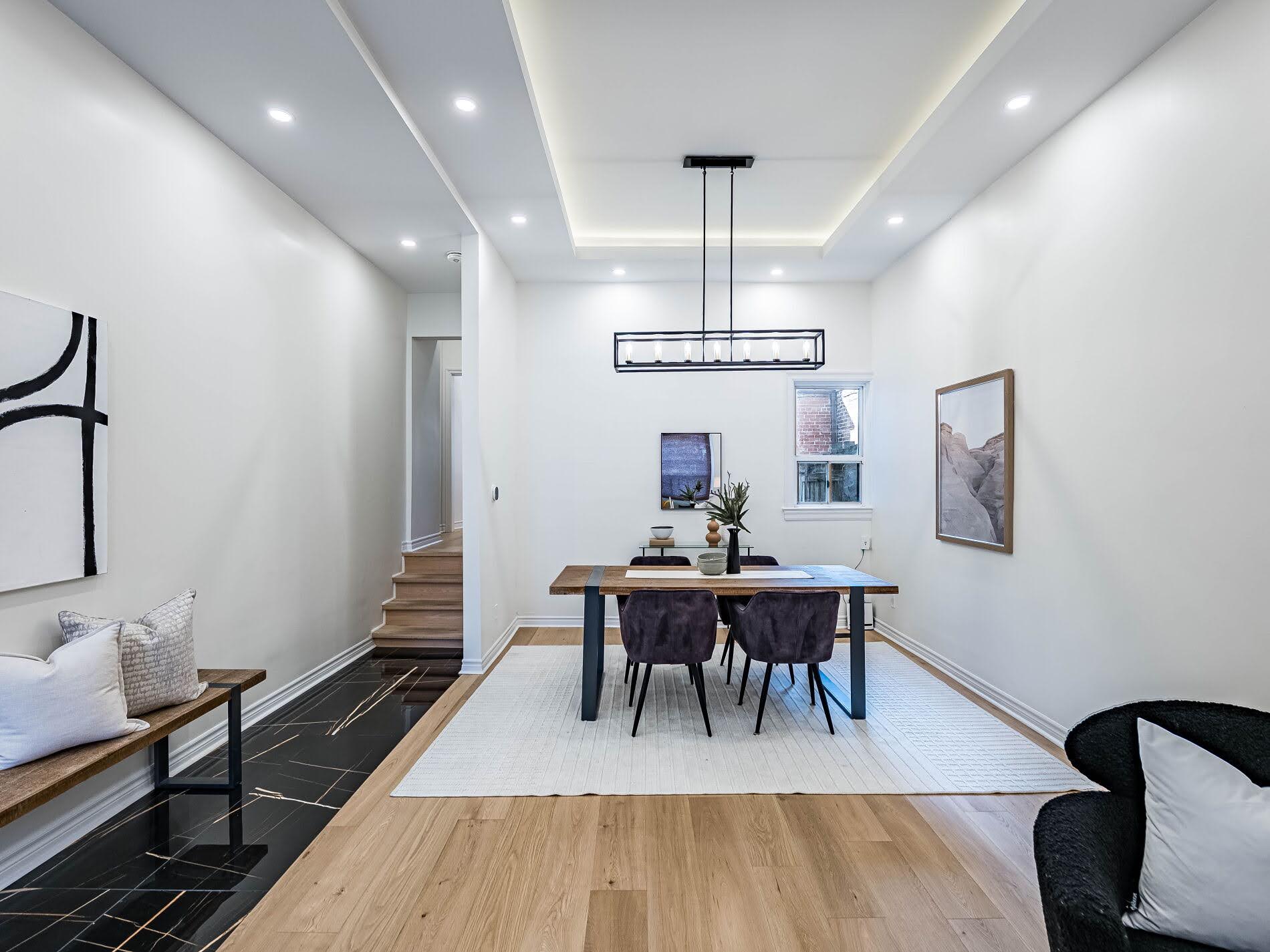 Dining room with pot-lights, chandelier, hardwood floors, and black-tiled floors.