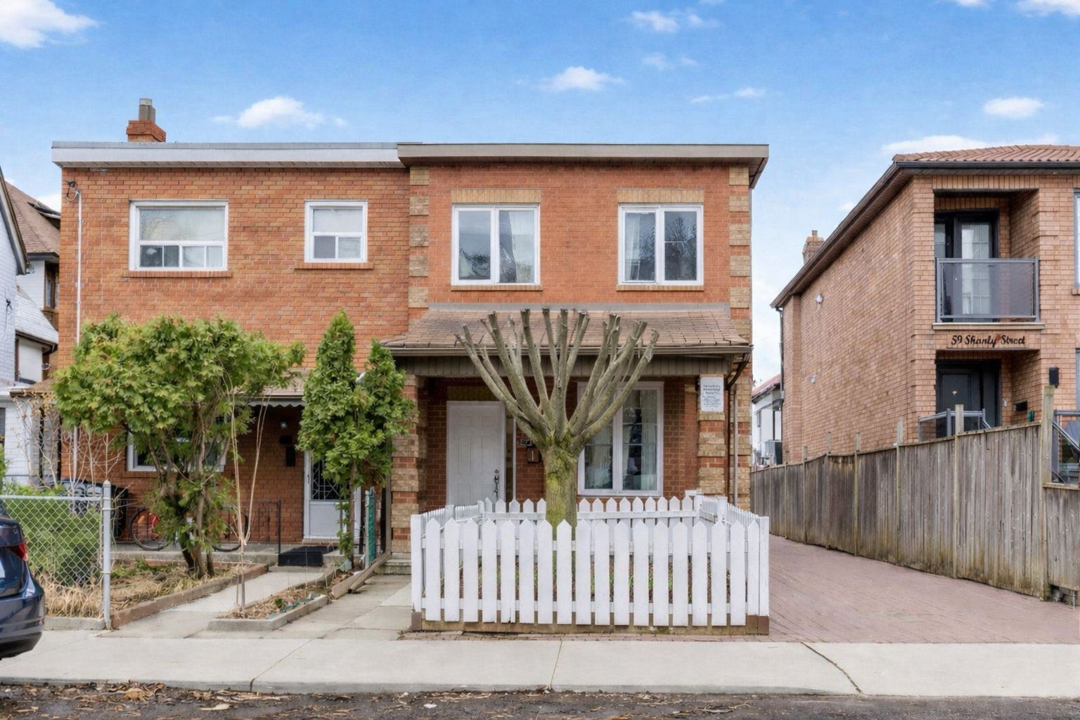 Front view of 57 Shanly St, a 2-storey redbrick duplex with a flat roof.