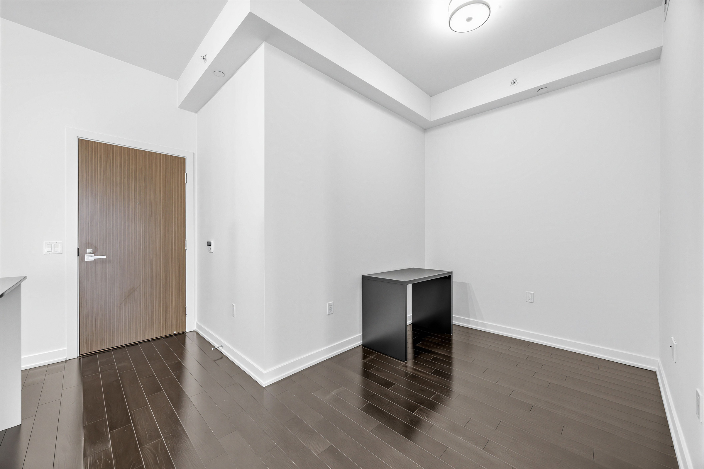 Condo den with dark brown hardwood floors and an LED ceiling light.
