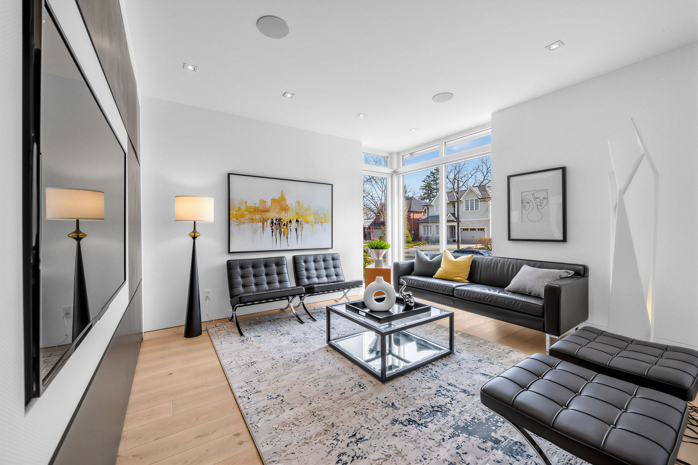 Family room with 3 large windows and several recessed lights in ceiling.