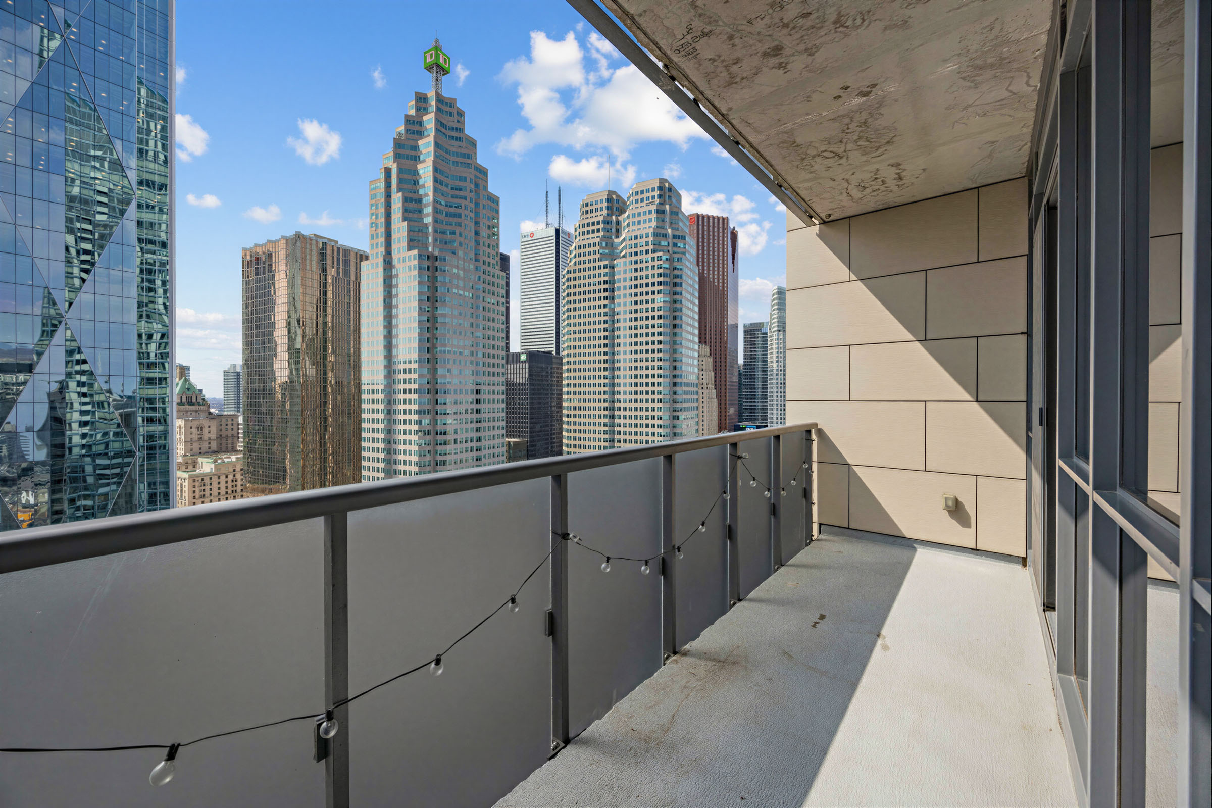 1 The Esplanade Unit 3403 balcony with concrete floors, opaque panels, beige walls, showing TD Tower and other commercial buildings. 