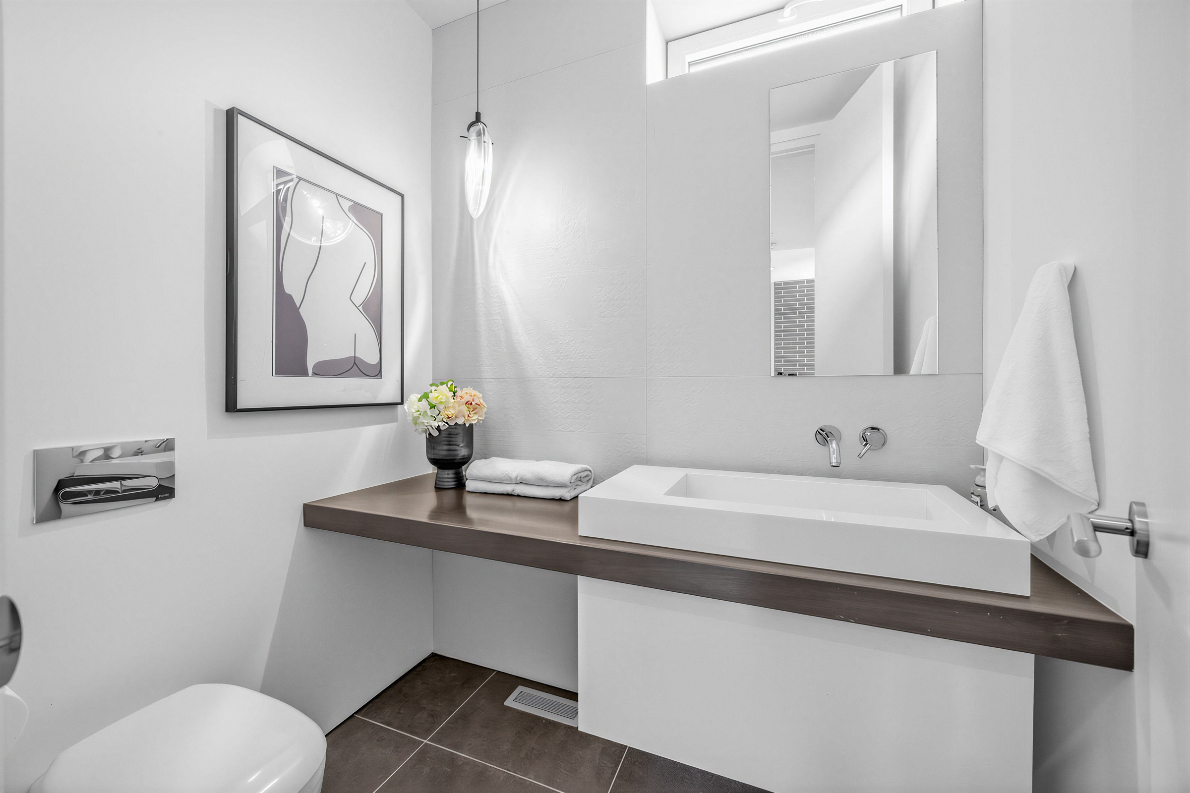 52 Burrows Ave minimalist powder room with vessel sink, wall-mounted faucet, narrow vanity in paneled wall, dark tiles, and pendant light.