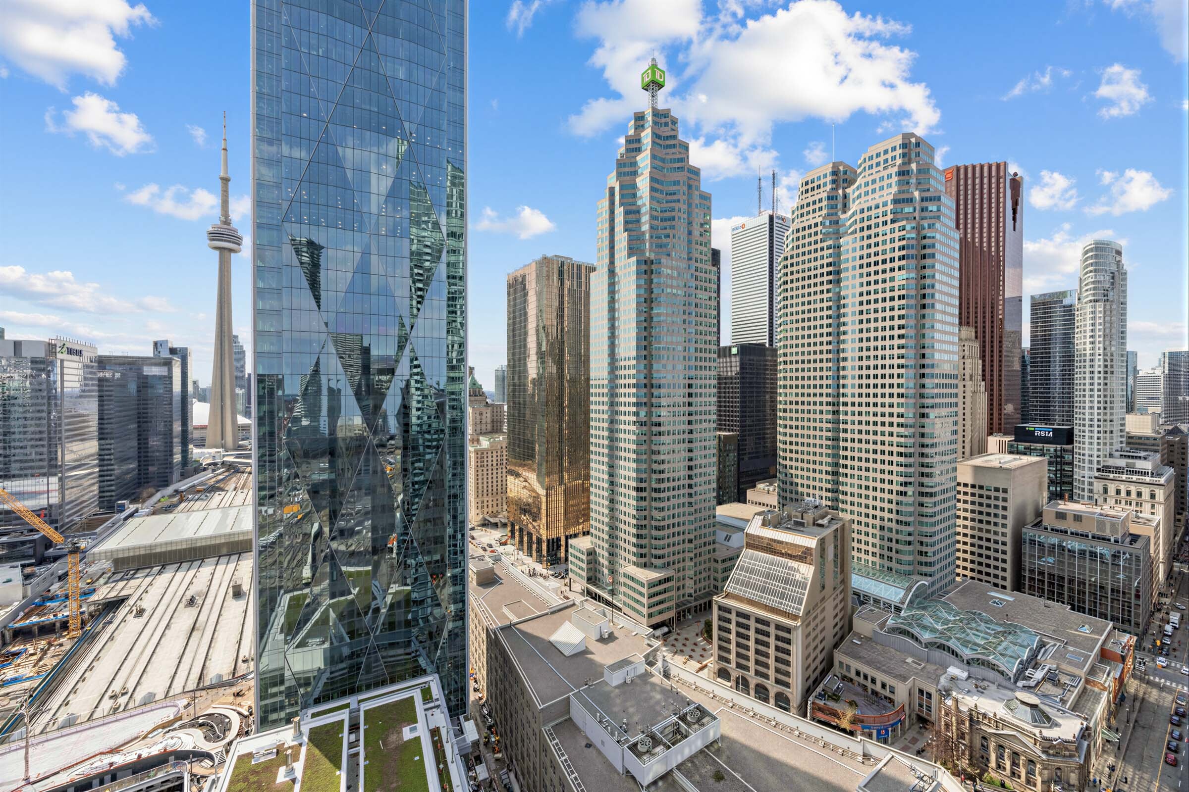 Condo balcony showing gleaming buildings, blue skies and the CN Tower.