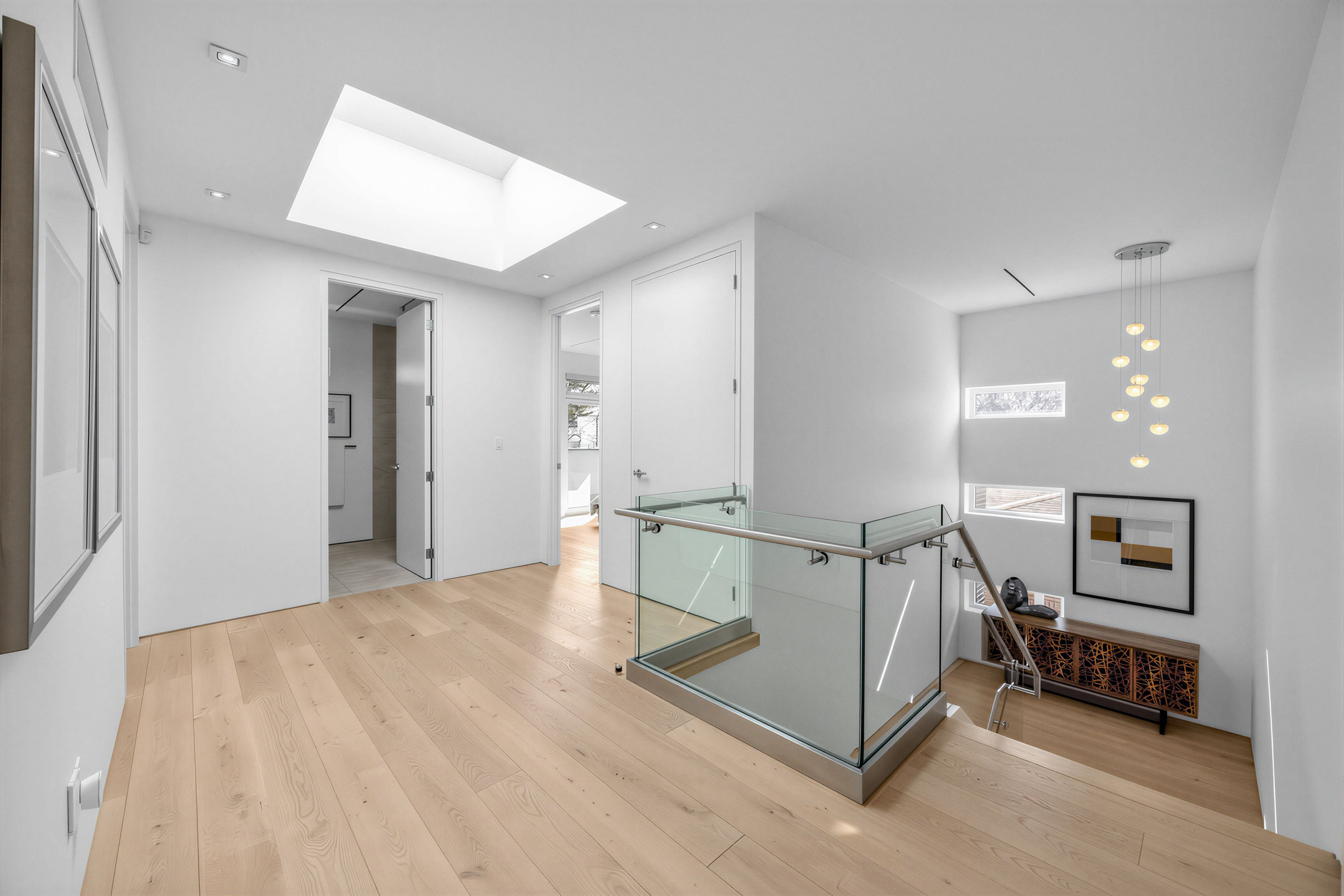Staircase with stylish chandelier with multiple spherical bulbs.