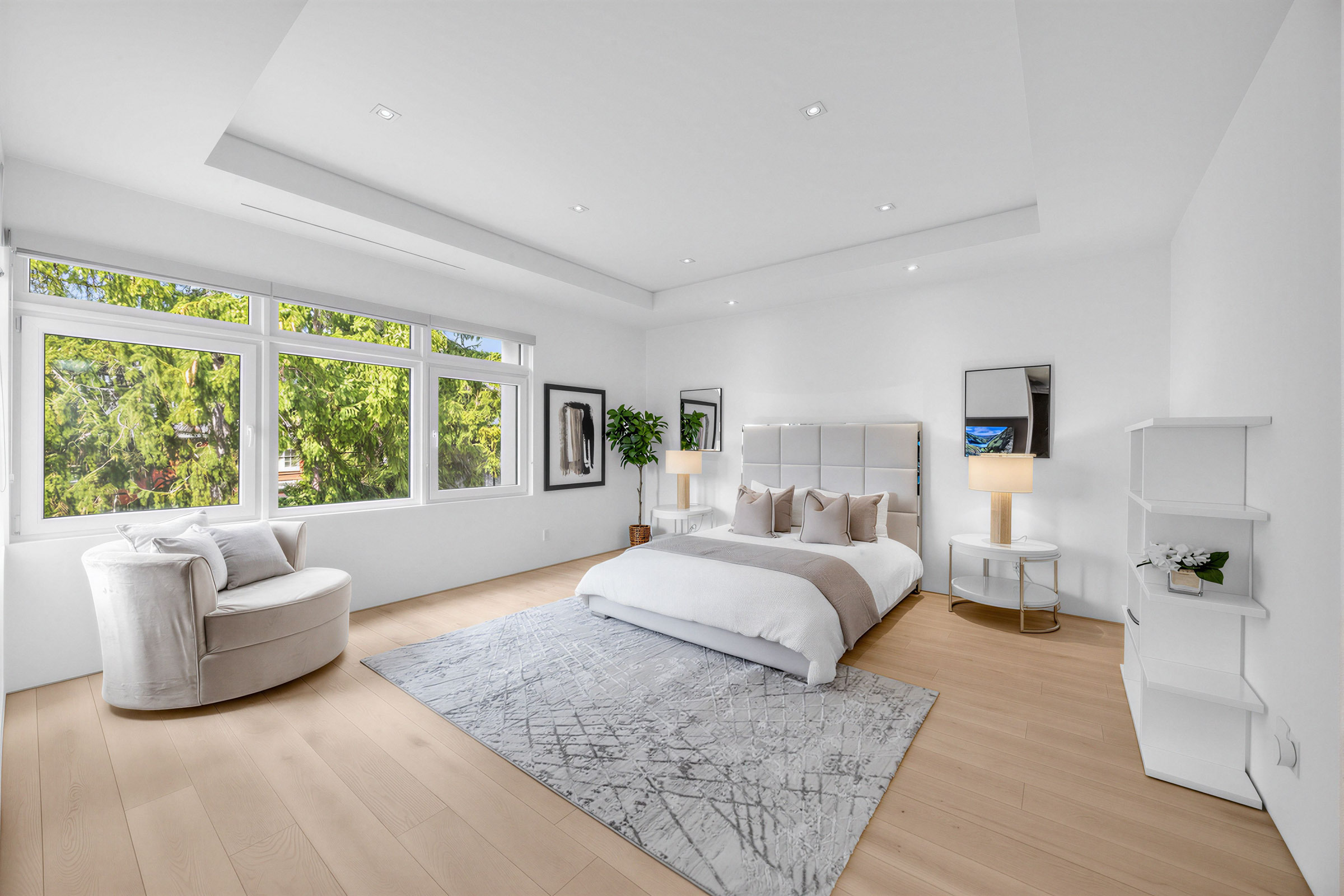 52 Burrows Ave large, brightly lit primary bedroom with bed, furniture, high ceilings, hardwood floors, gray walls, windows and pot-lights.