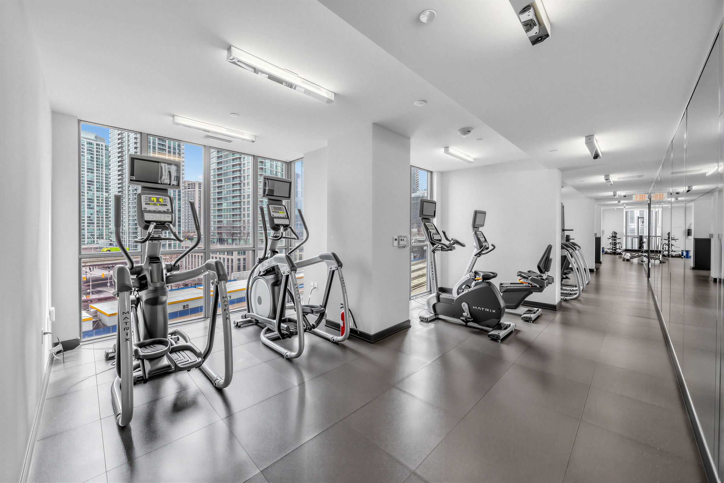 Backstage Condos gym amenity with exercise bikes facing windows.