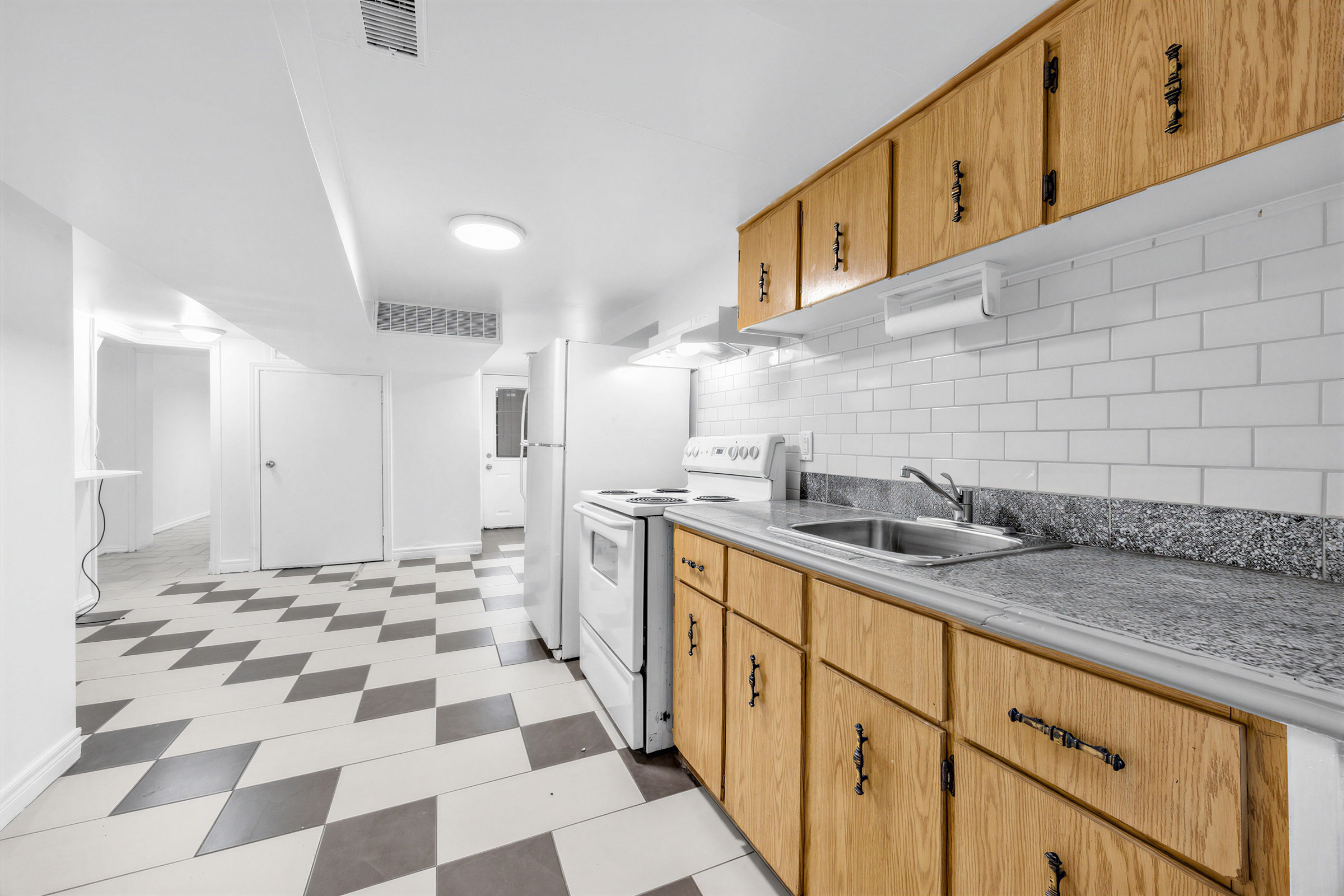 Large finished basement with white and brown colours.