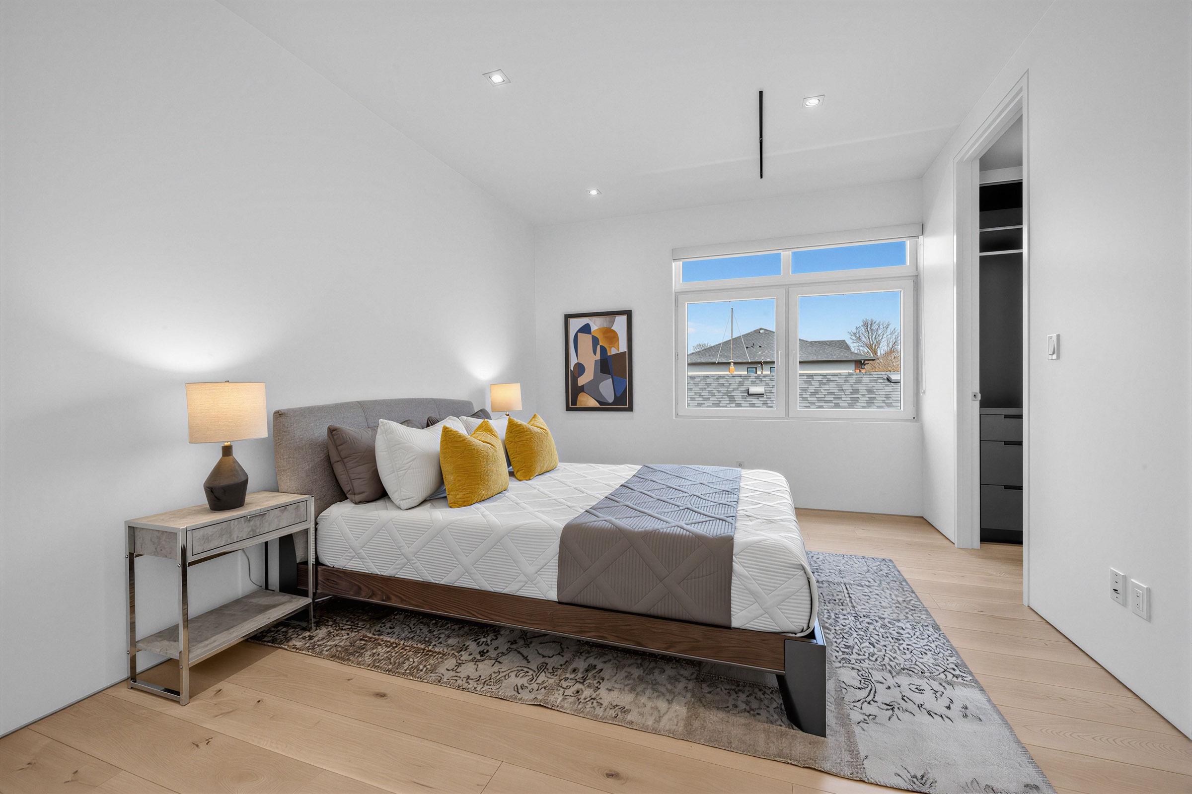 Photo of 52 Burrows Ave 2nd bedroom with large bed, hardwood floors, window and recessed lights.