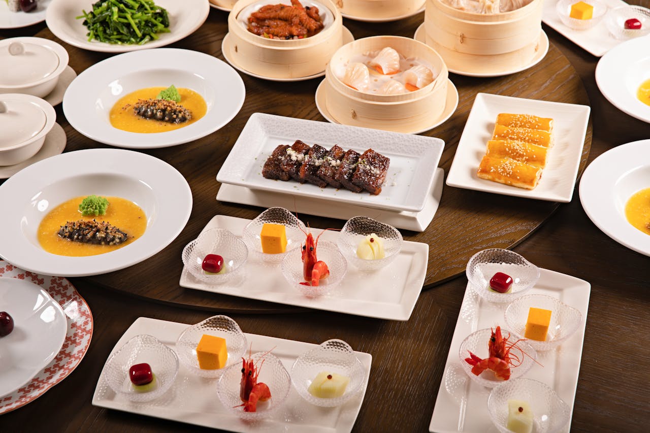 Table laded with multiple dishes of Chinese food, including main course, dessert and snacks.