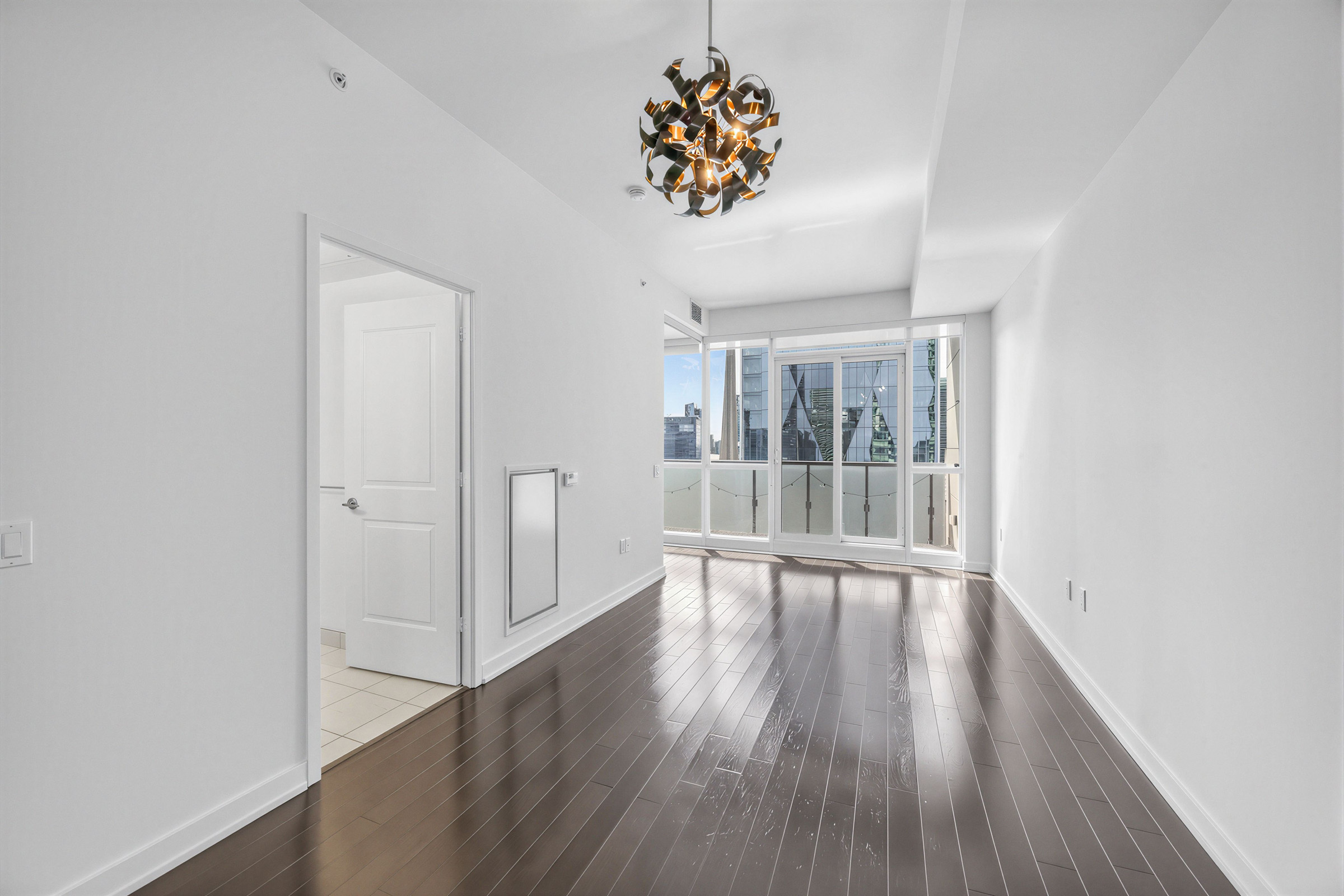 Condo living room with new, shiny dark brown floors.