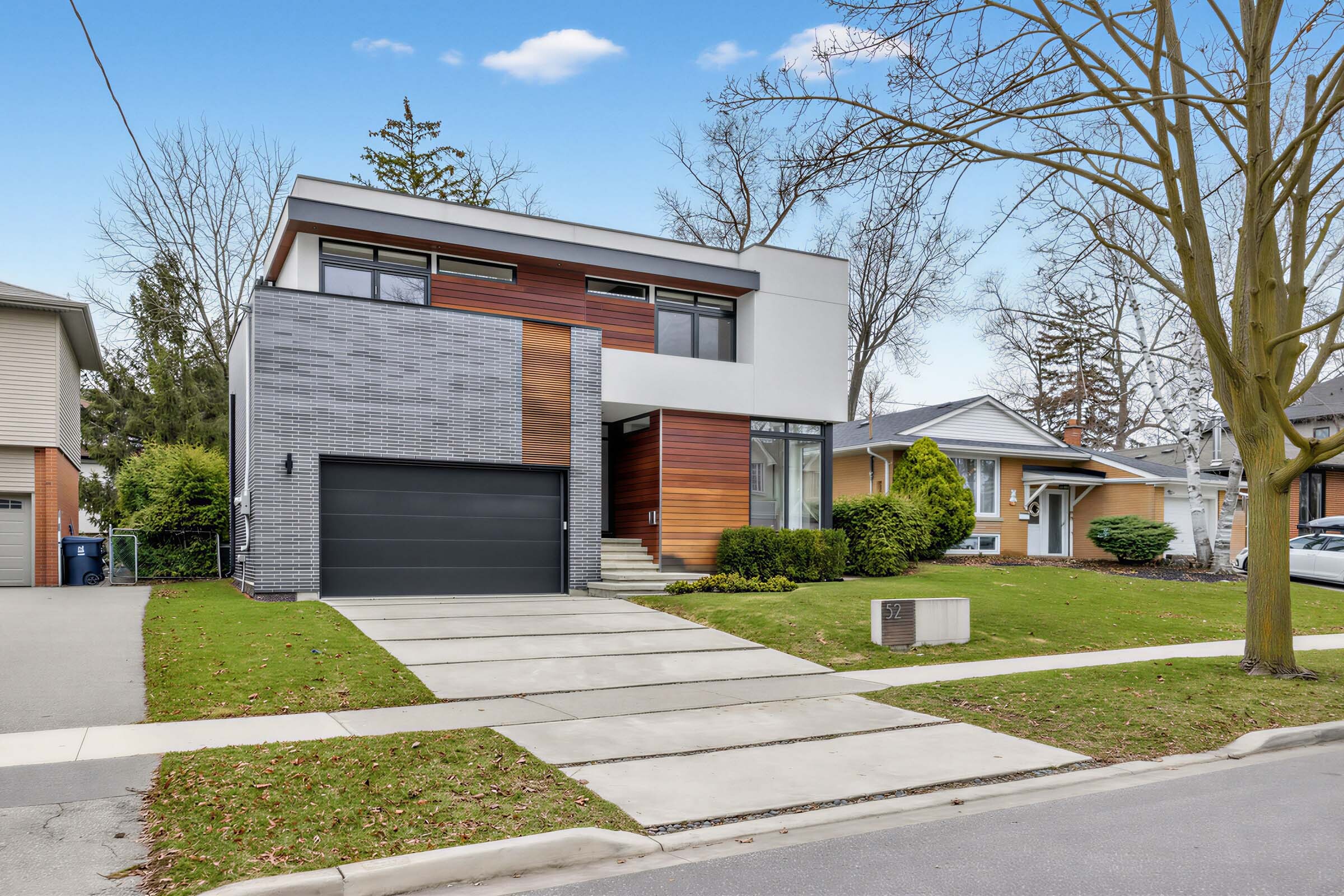 Side view of house with spacious driveway and black garage.