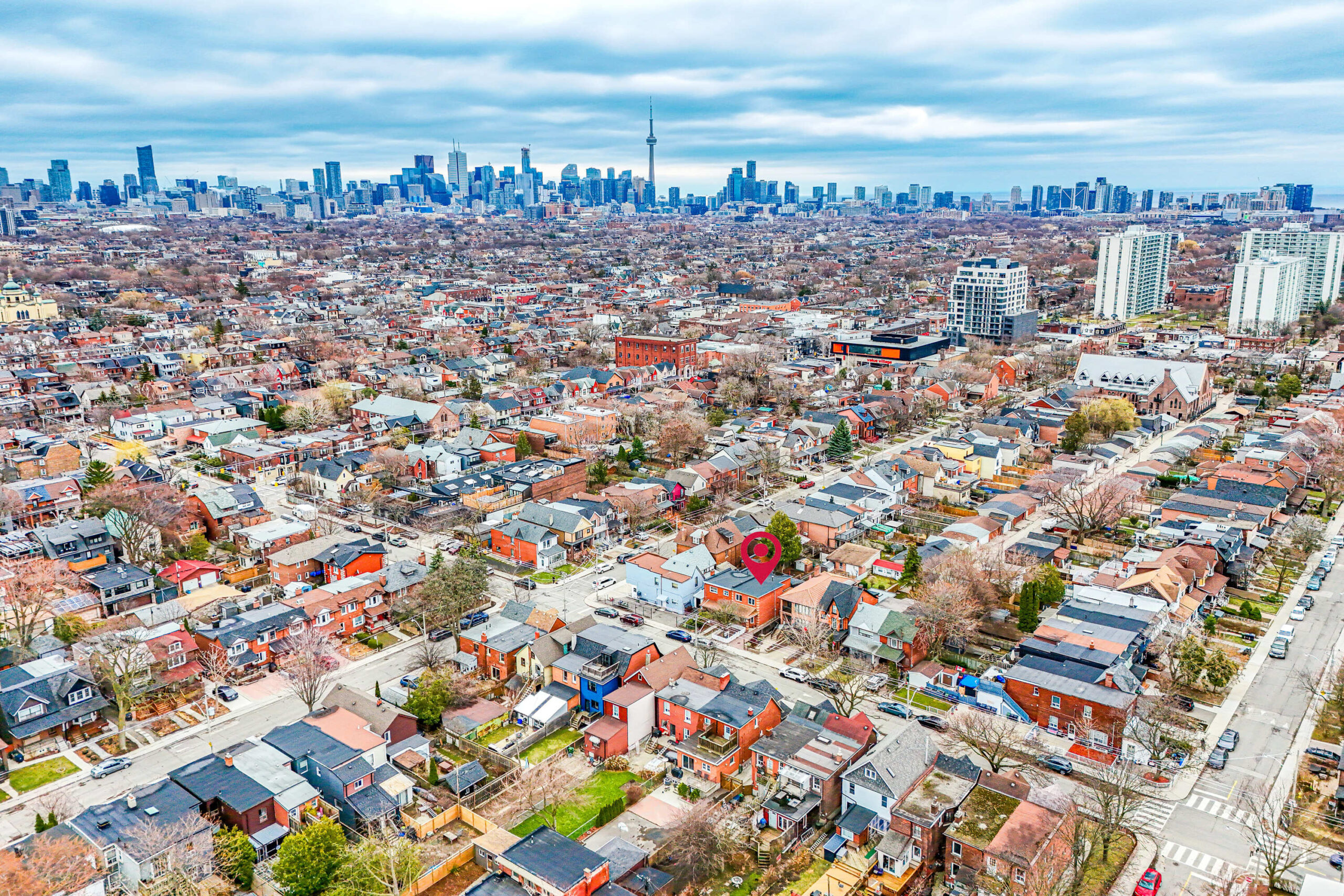 Aerial drone photo of Dovercourt Village in foreground, and Toronto skyline with CN Tower in background.