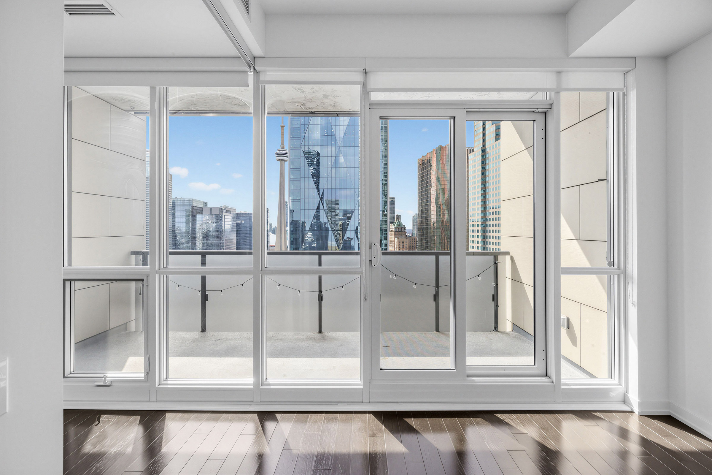 View of blue skies, shining buildings and CN Tower from living room windows of 1 The Esplanade Unit 3403.