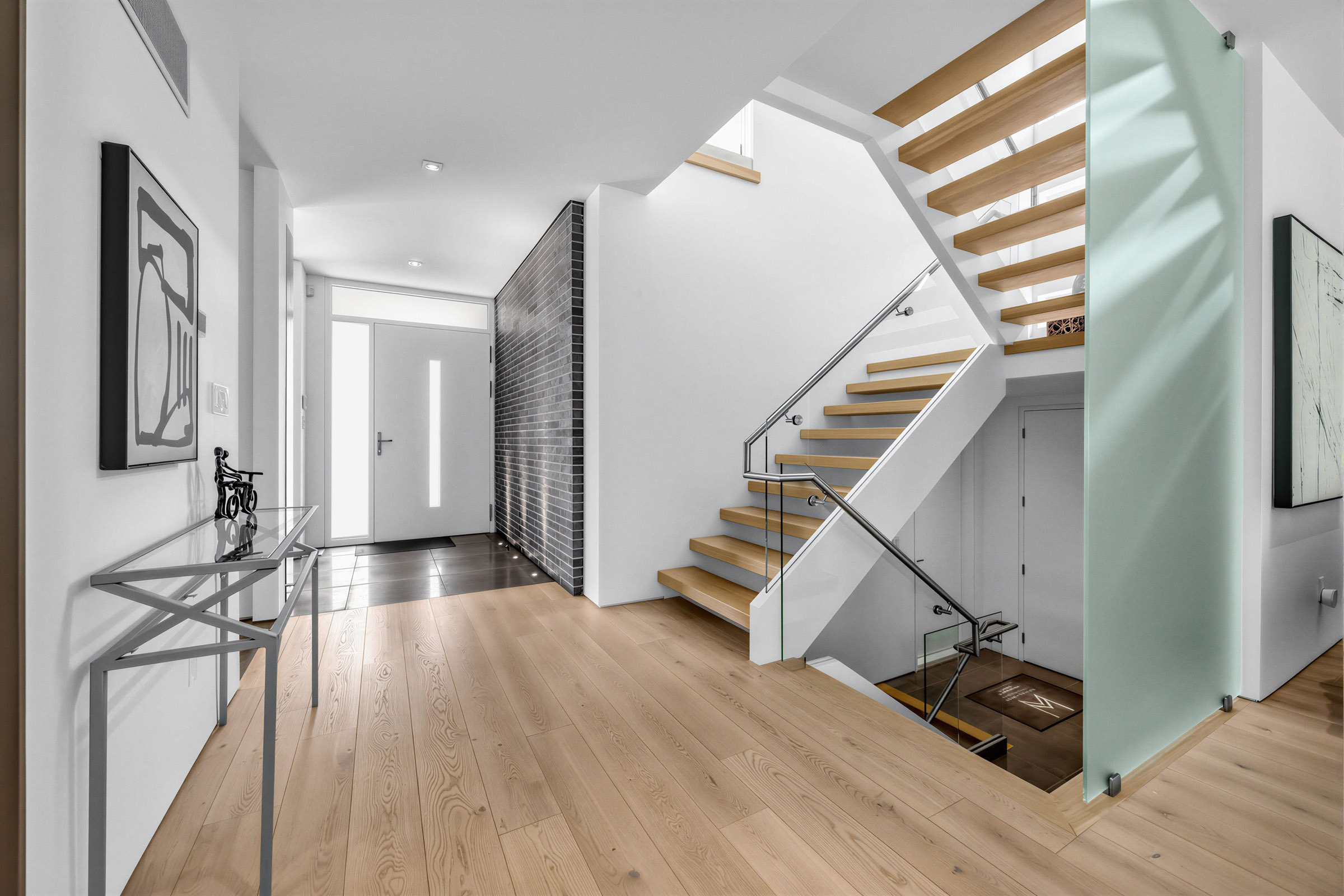 52 Burrows Ave entrance with black brick accent wall on right and black tiled floors with uplights below.