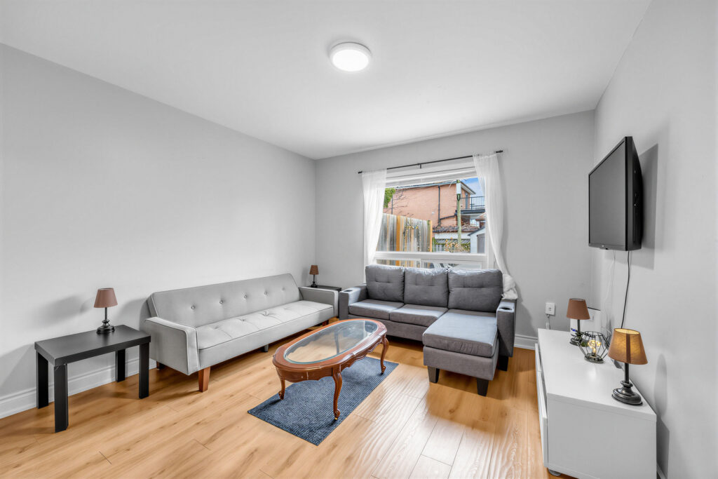 Bedroom being used as living room, with living furniture and TV.