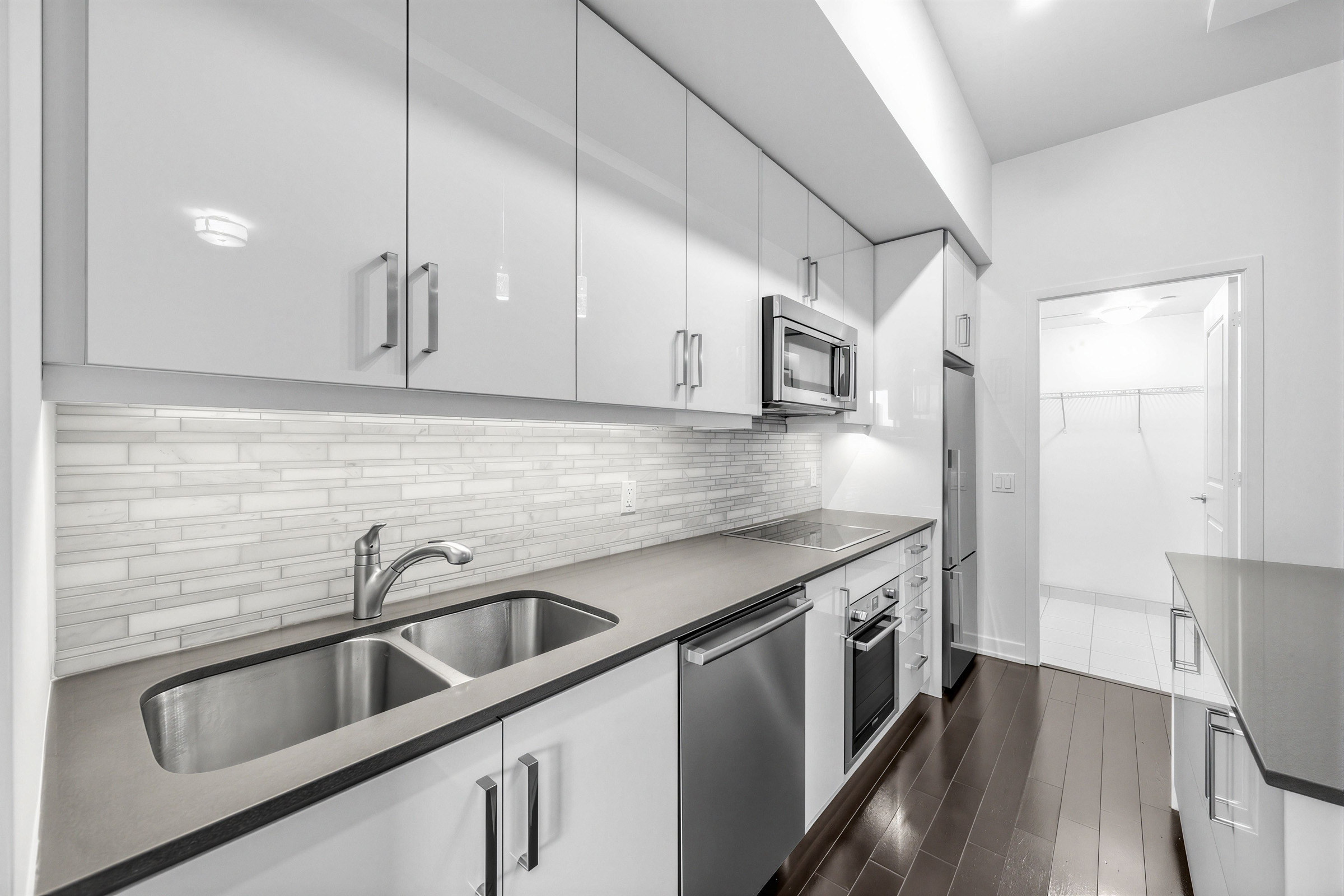 Kitchen with gray-white staggered, horizontal subway-style backsplash.