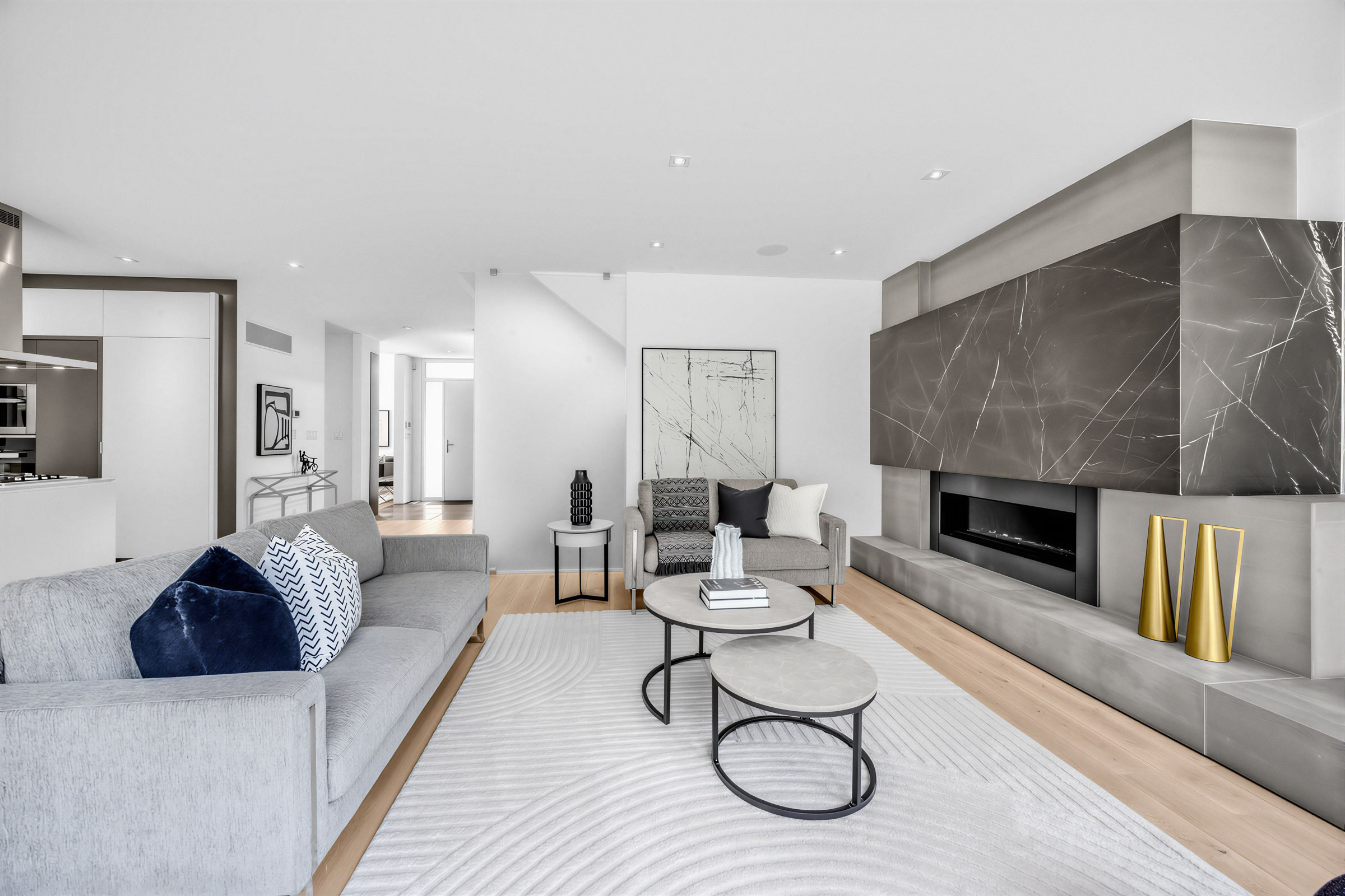 52 Burrows Ave living room with raised gas fireplace and wall with dark marble slab with white veining.