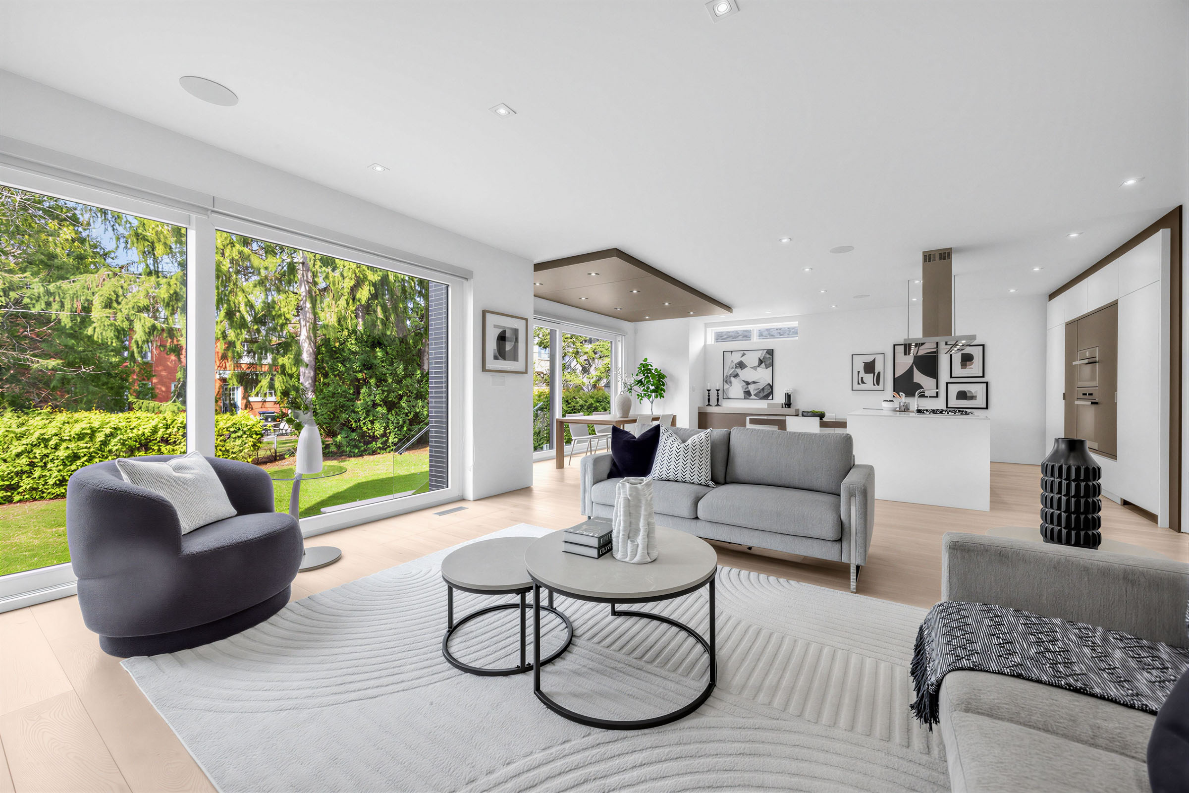Living room with large windows showing sunny backyard full of trees, shrubs and lawn.