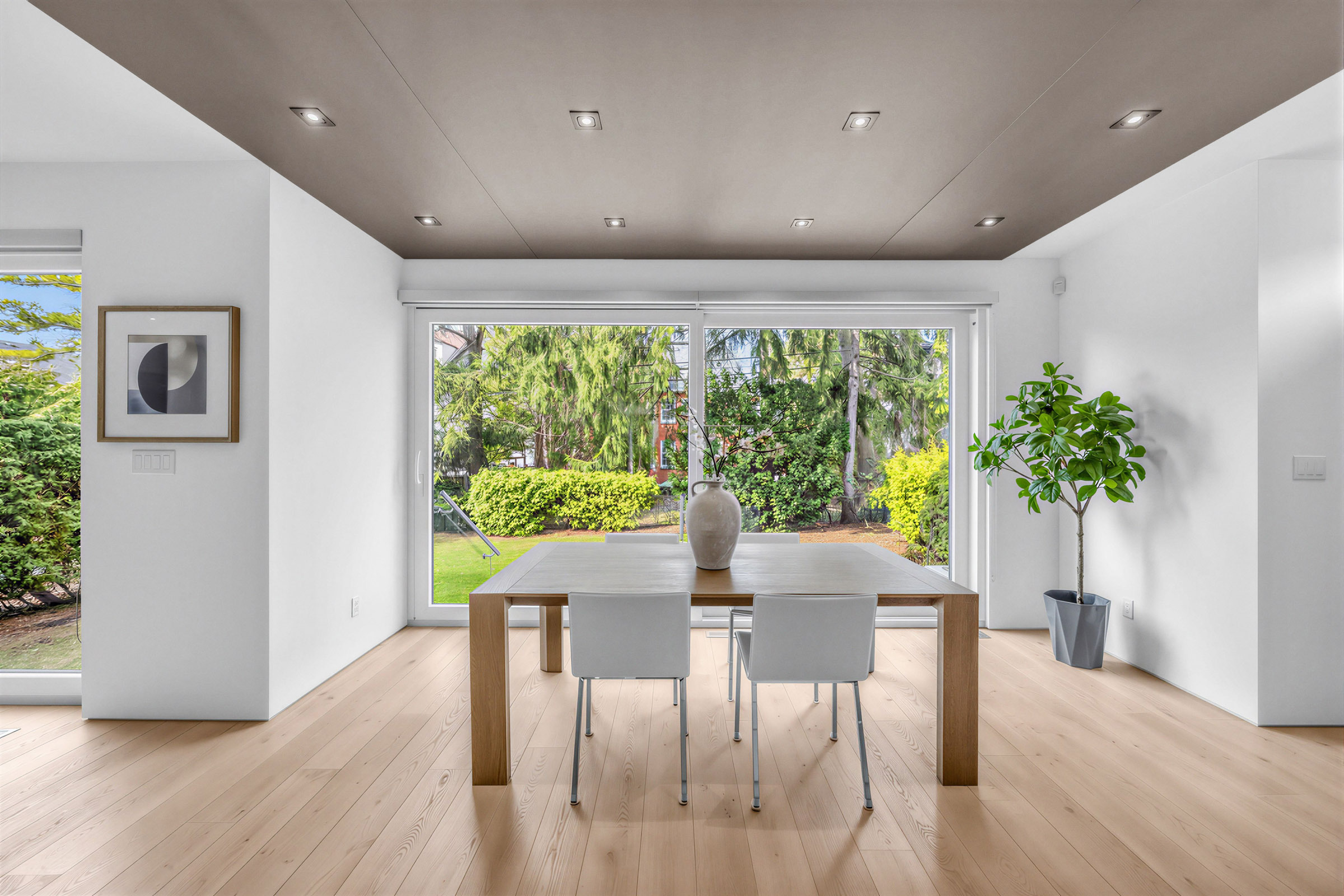 52 Burrows Ave dining room with table, chairs, dark brown dropped ceiling, hardwood floors, and view of backyard through large glass doors.