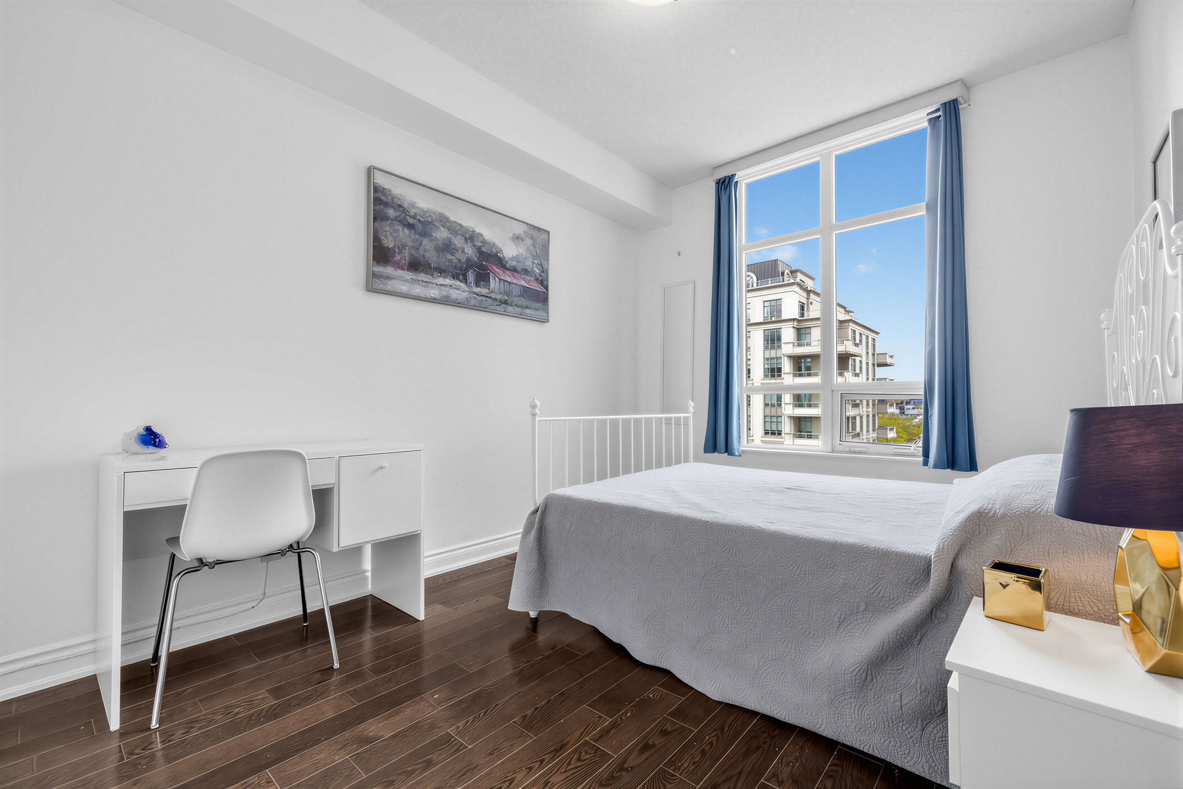 Second spacious bedroom with large bed, night stand and desk with chair – 20 Bloorview Place Unit 1003.