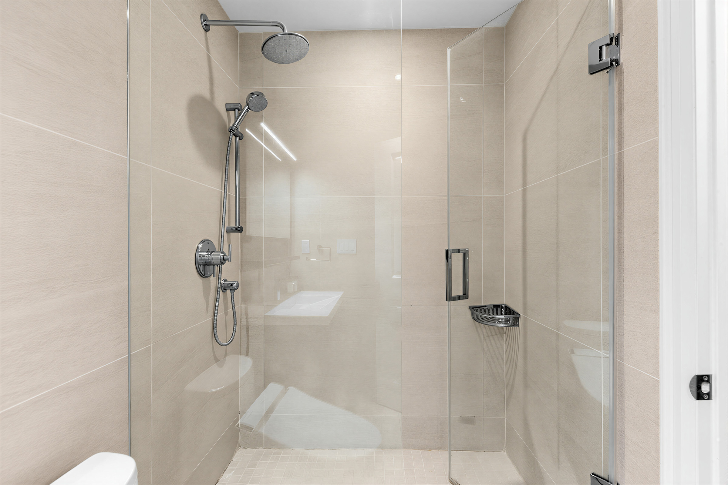 Condo bathroom with frameless glass enclosure and rainshower head.