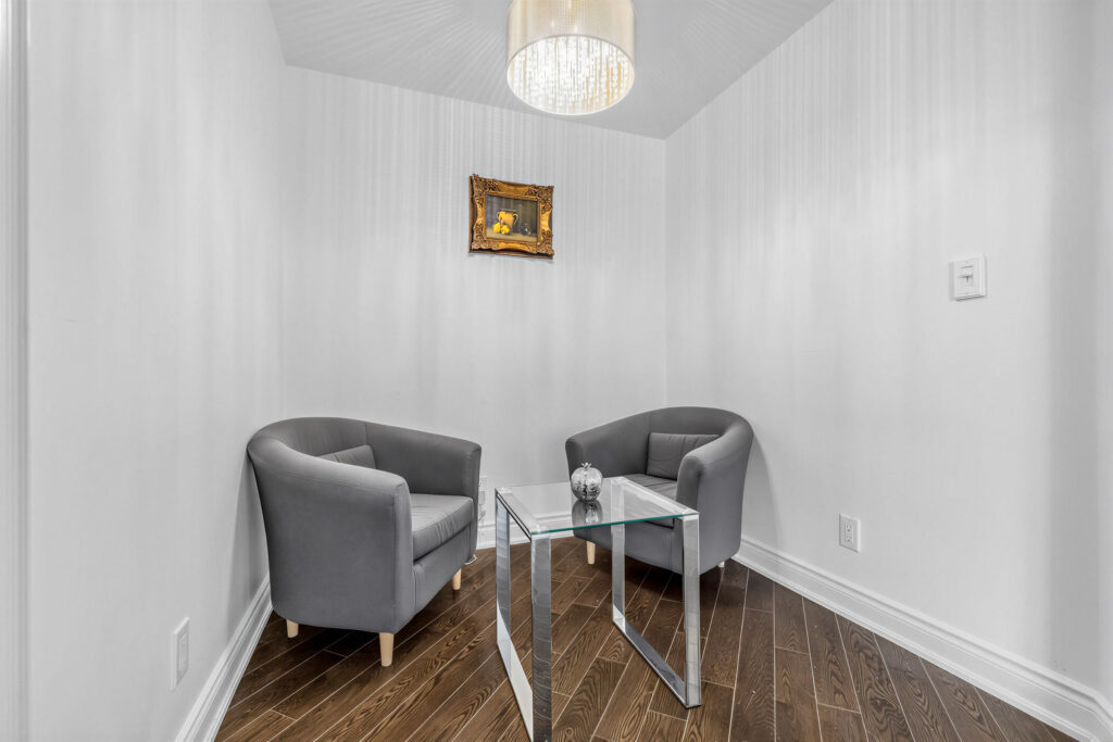 20 Bloorview Place Unit 1003 den with 2 chairs, a table, hardwood floors and a drum-shade chandelier above.