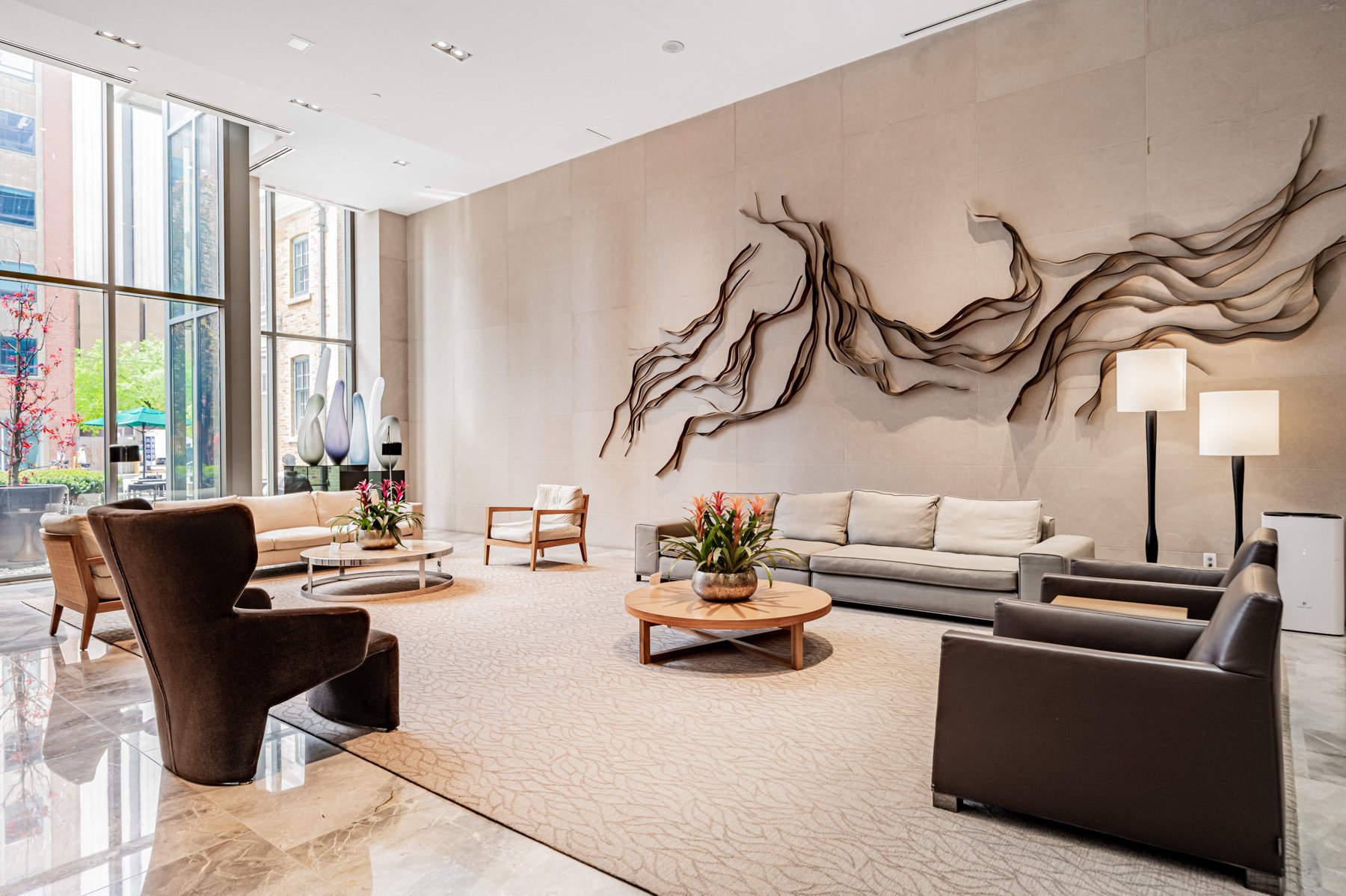 Luxurious lobby of One Bedford condos with modern furniture, warm colours and wall art.
