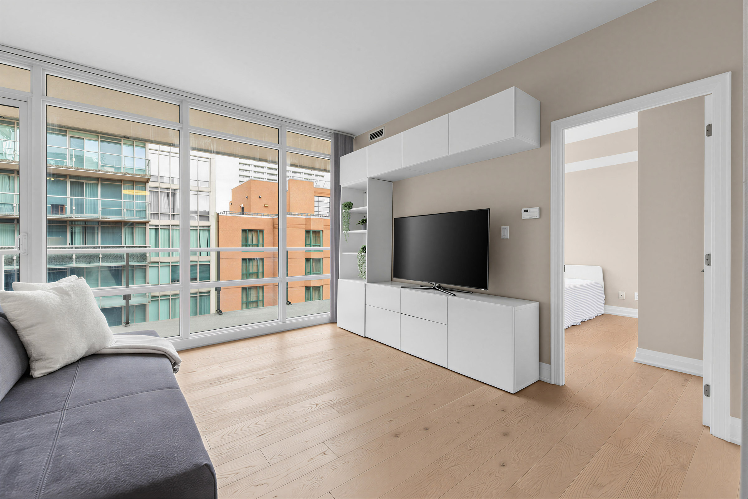 1 Bedford Rd Unit 603 custom-built entertainment unit with open shelves, handle-free cabinets and TV.