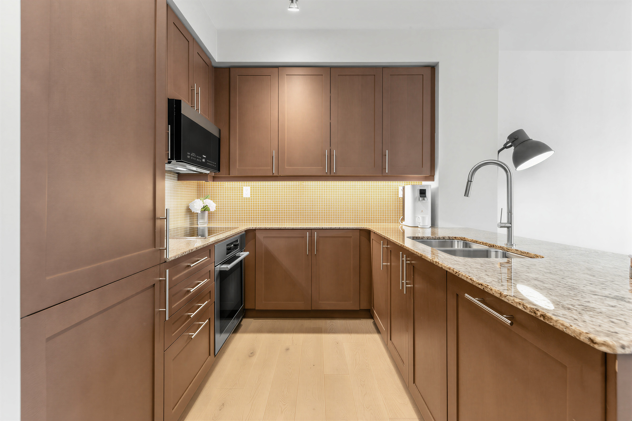 1 Bedford Rd Unit 603 U-shaped kitchen showing counters, cabinets and backsplash.